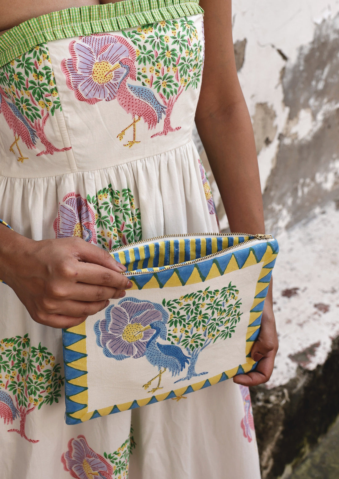 The Raw India Saras Crane pouch bag featuring a vibrant crane design, made from eco-friendly materials, with a zipper closure.