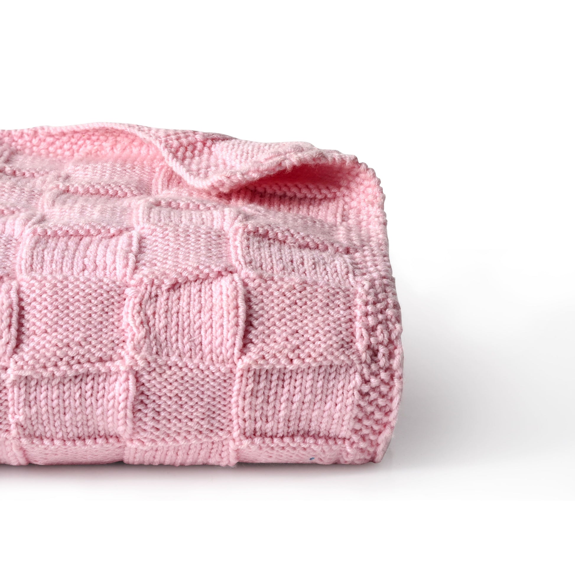 Pink Merino wool blanket by Masaya Home, soft and cozy with a plush texture, shown draped on a bed.