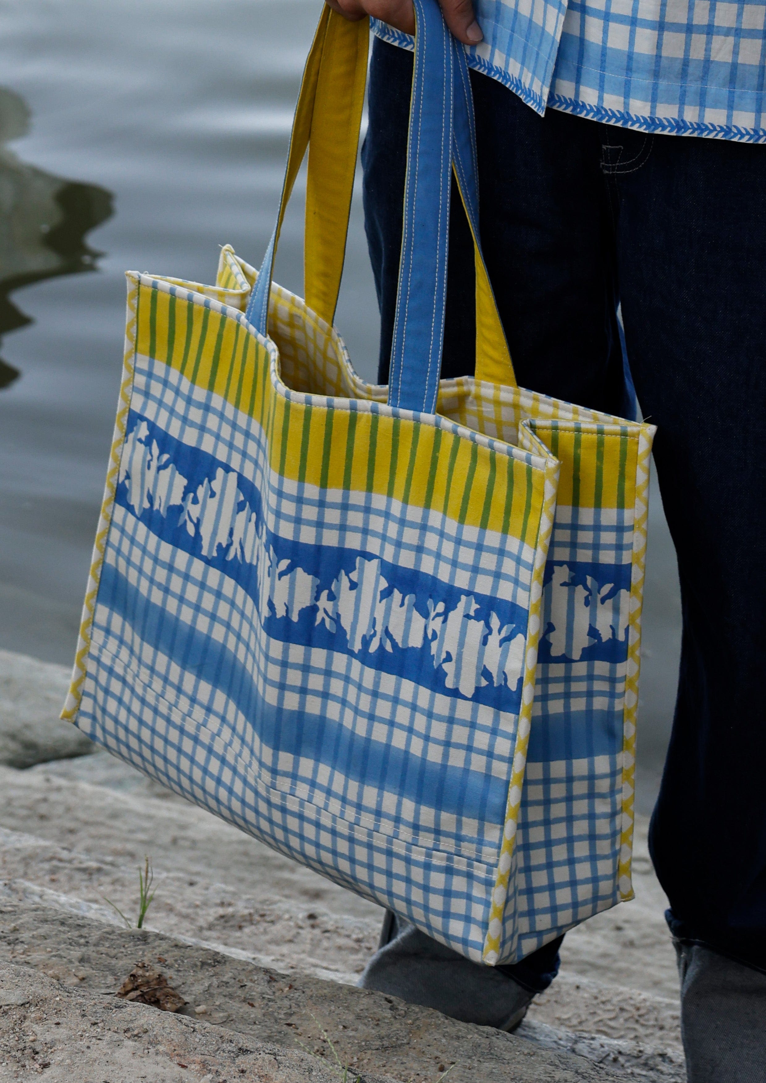 Blue checkered tote bag from The Raw India, showcasing spacious design and sturdy handles for everyday use.