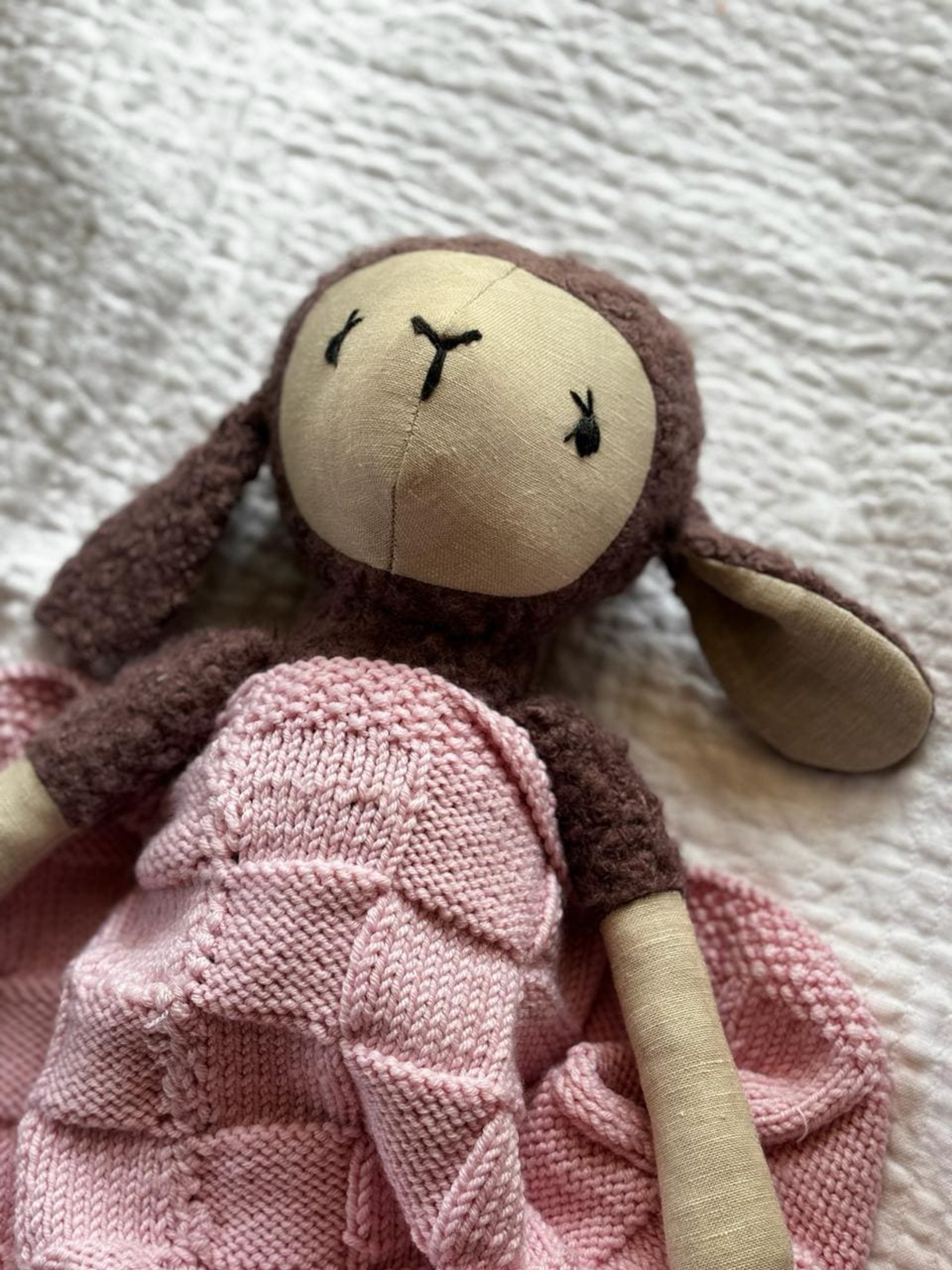 Pink Merino wool blanket by Masaya Home, soft and cozy with a plush texture, displayed folded on a neutral surface.