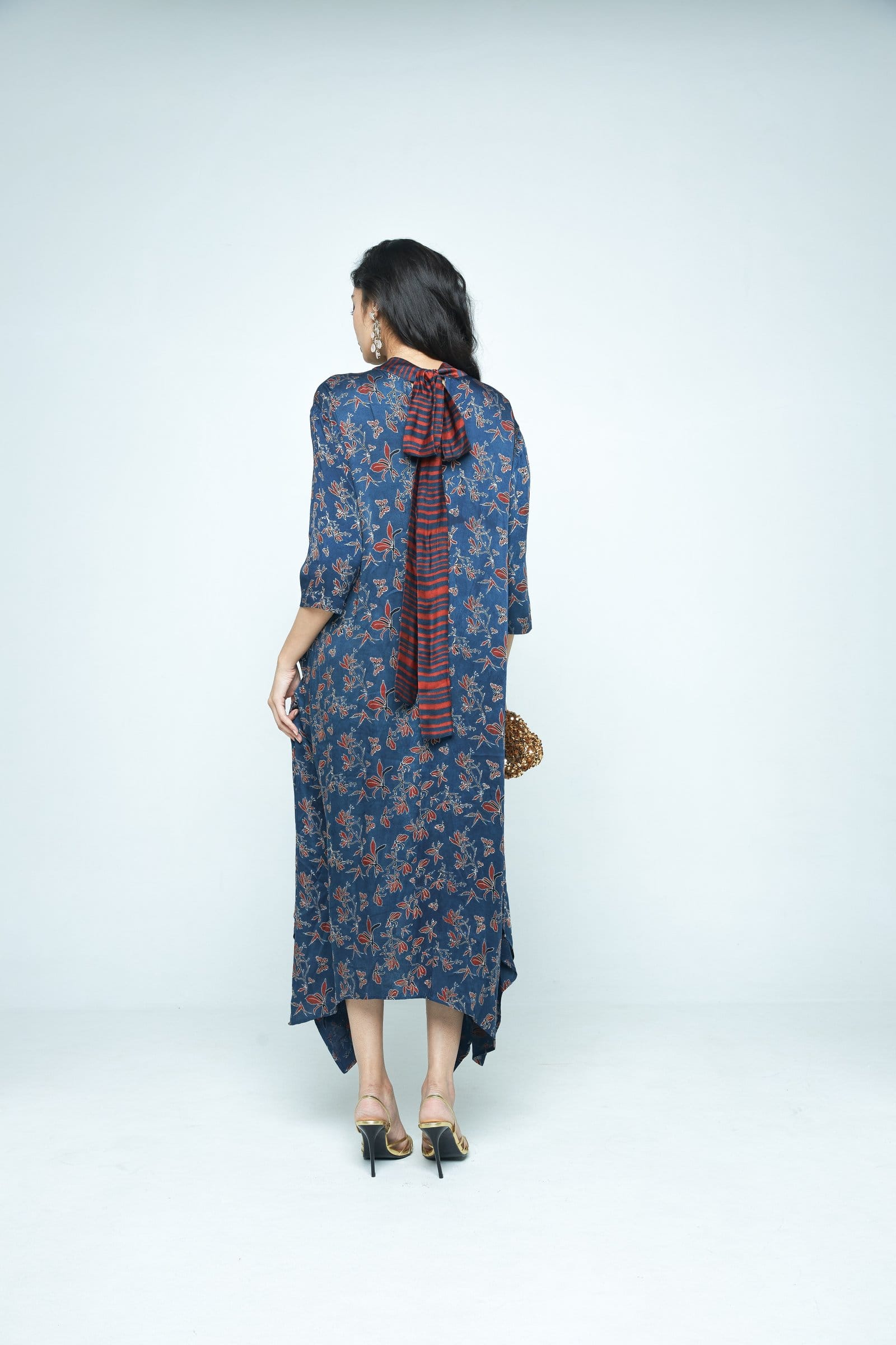 Back view of Anushe Pirani Cascade dress, elegant long dress with intricate details and flowing fabric.