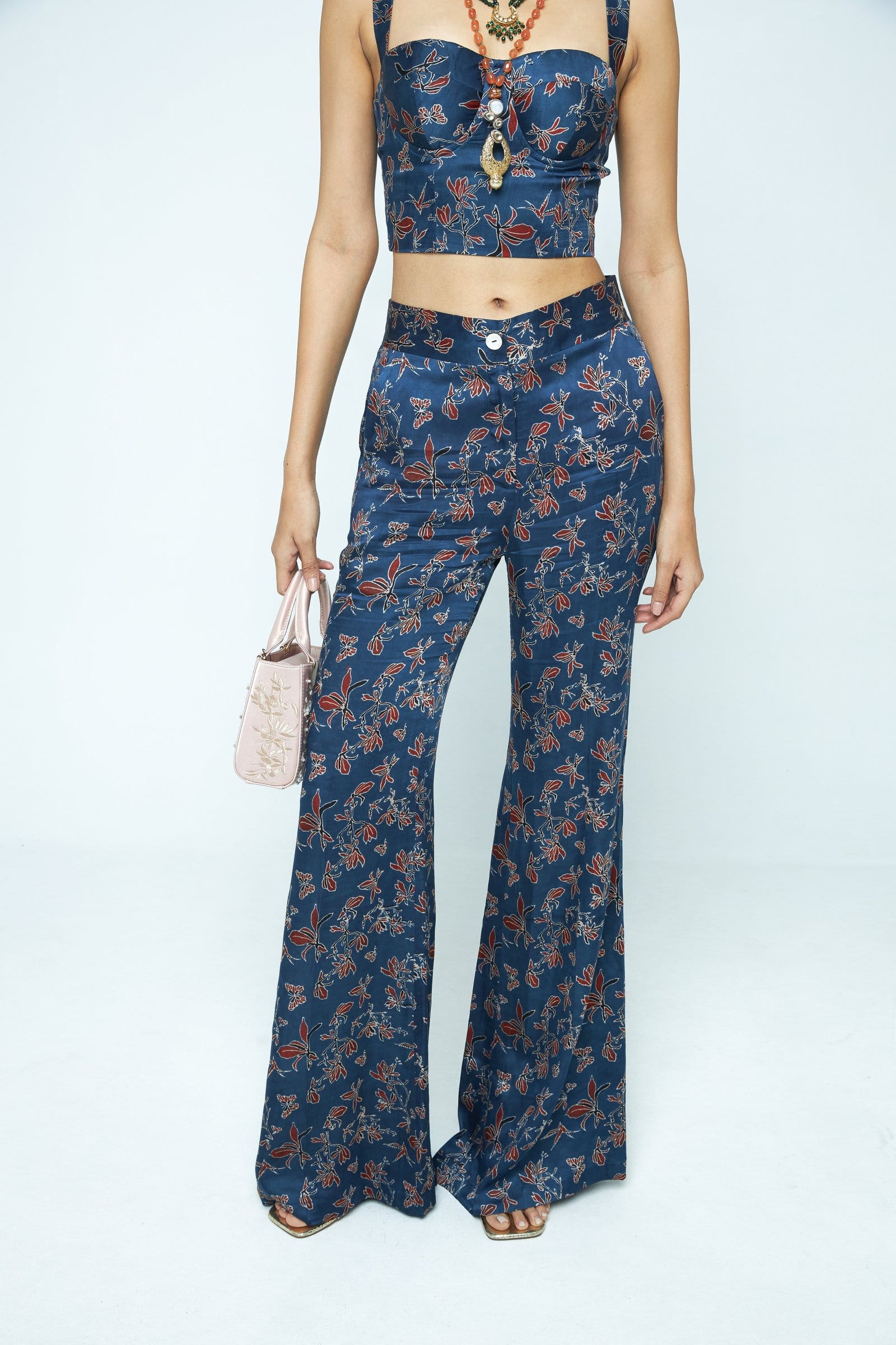 Anushe Pirani Paradise flare pants shown front view with high waist and flowing fabric in vibrant pattern.