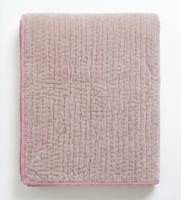 Soft blush rose velvet reversible quilt from Bombaybirds, showcasing plush, taupe-colored fabric on a cozy living room setting.