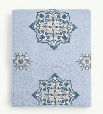 Light blue lilac Suzani quilt from Bombaybirds, shown as a decorative living room throw with intricate floral patterns.