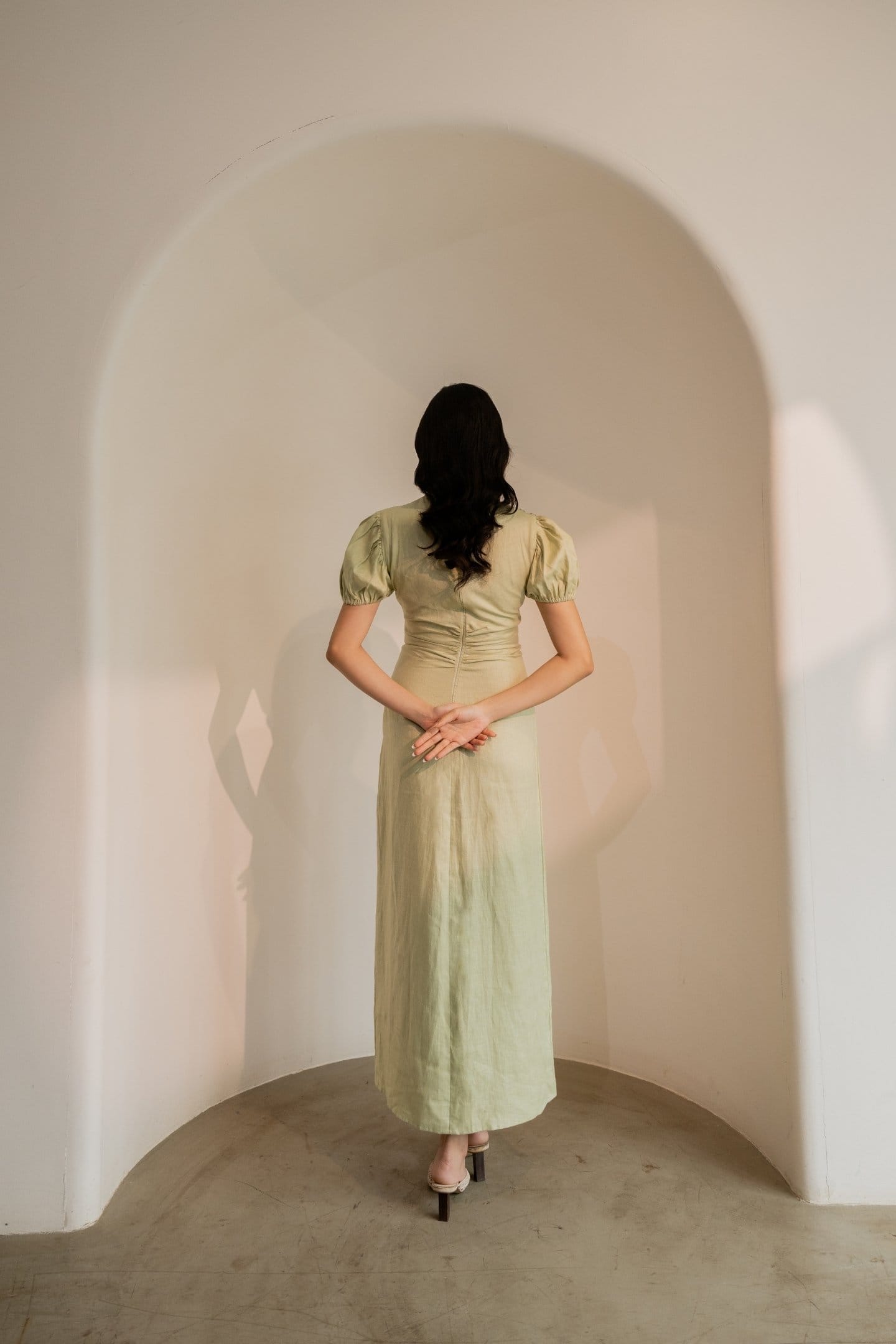 Dew mint green cinched maxi dress by Alternative, featuring a fitted waist and flowing fabric, displayed on a model.