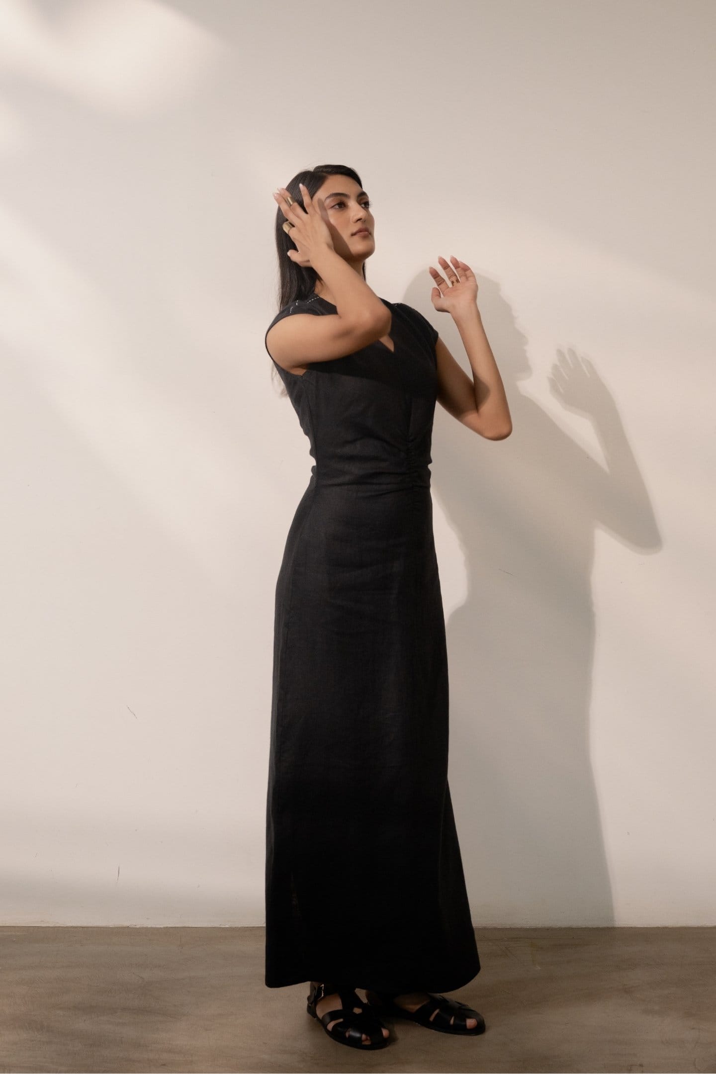 Ebony black cinched maxi dress by Alternative, featuring a fitted waist and flowing fabric, perfect for elegant occasions.