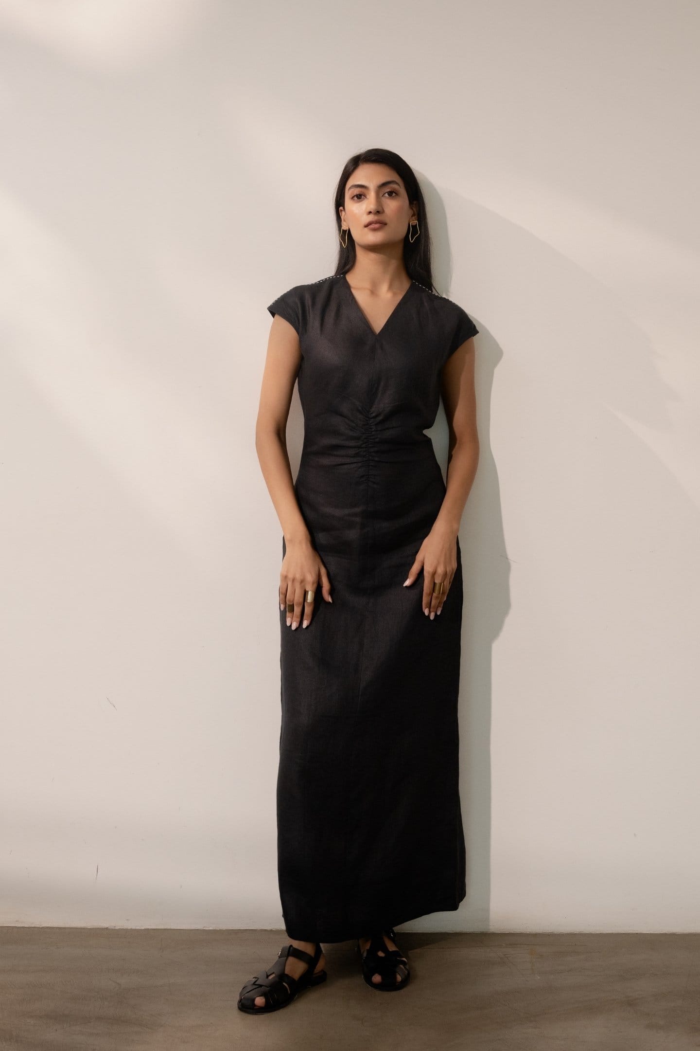 Ebony black cinched maxi dress by Alternative featuring a fitted waist and flowing fabric, displayed on a mannequin.