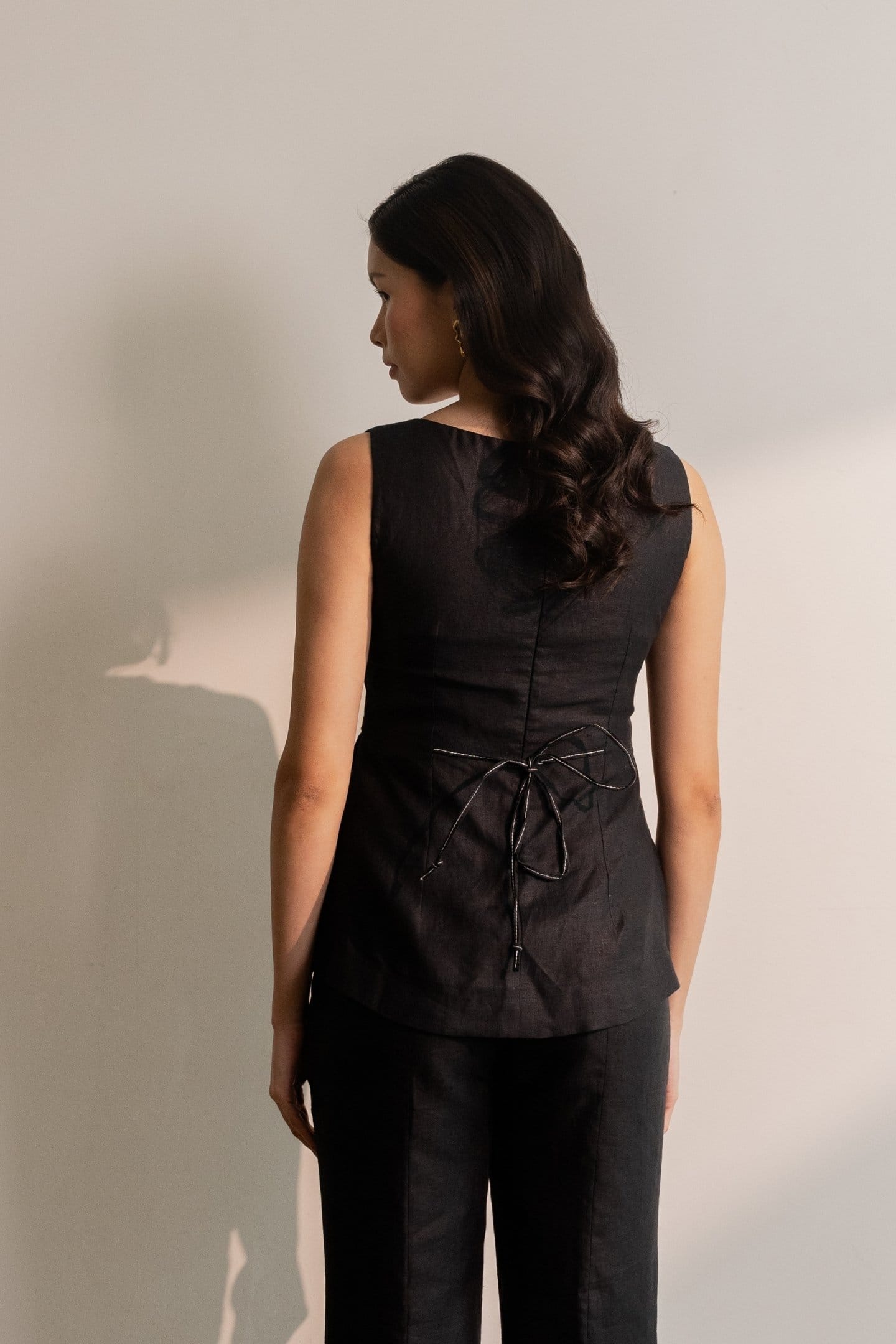 Ebony black sleeveless hemp top by Alternative, shown on a model, with a relaxed fit and sleeveless design.