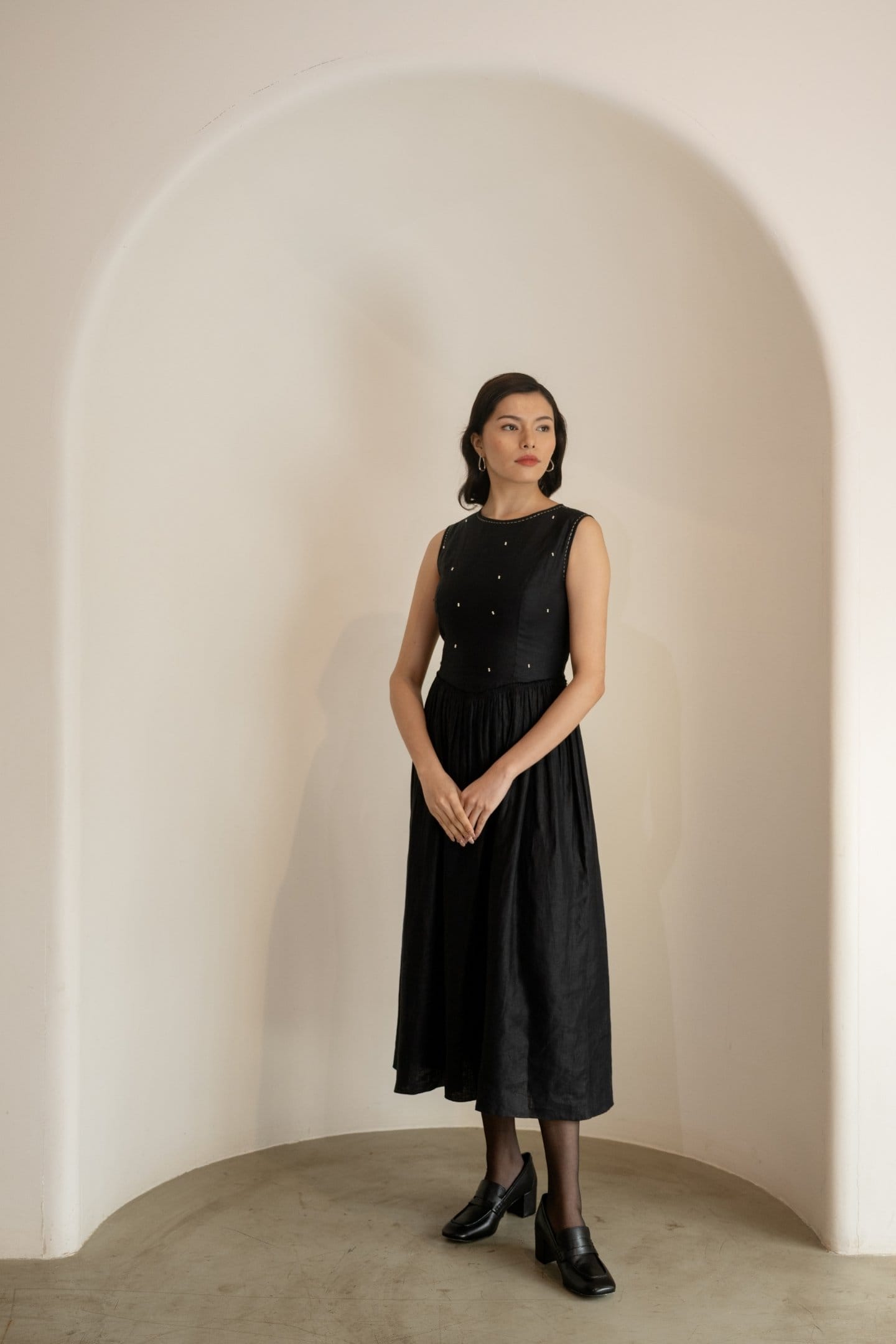 Ebony black sleeveless midi dress by Alternative, stylish maxi dress with a flowing silhouette and elegant design.
