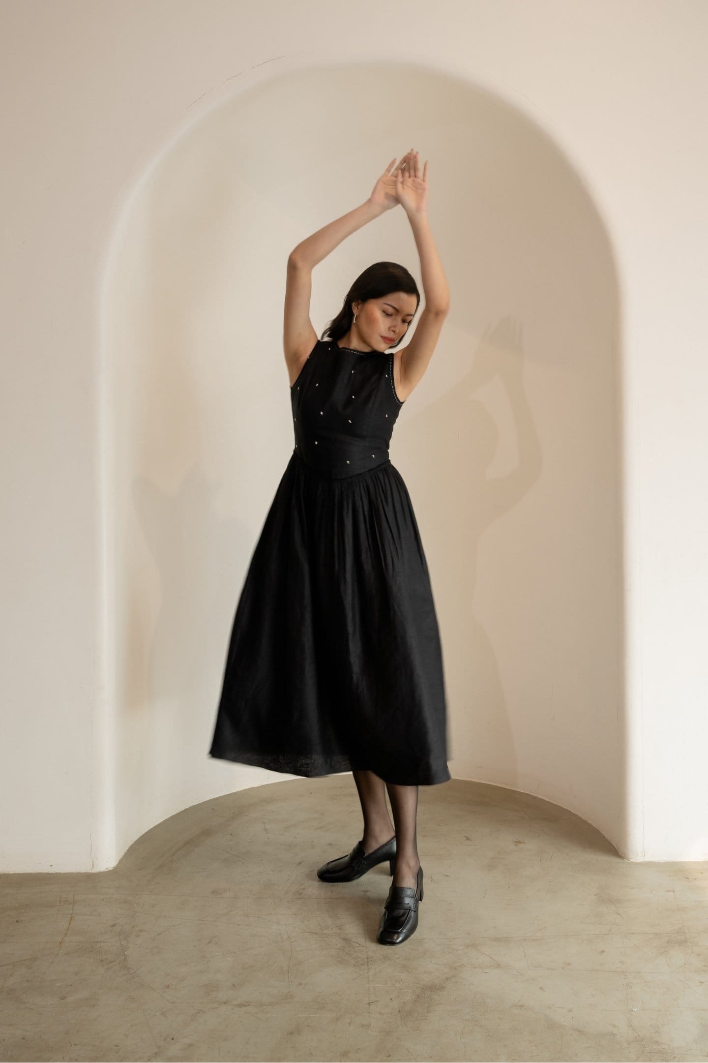 Ebony black sleeveless maxi dress by Alternative featuring a midi length, fitted waist, and flowing fabric.