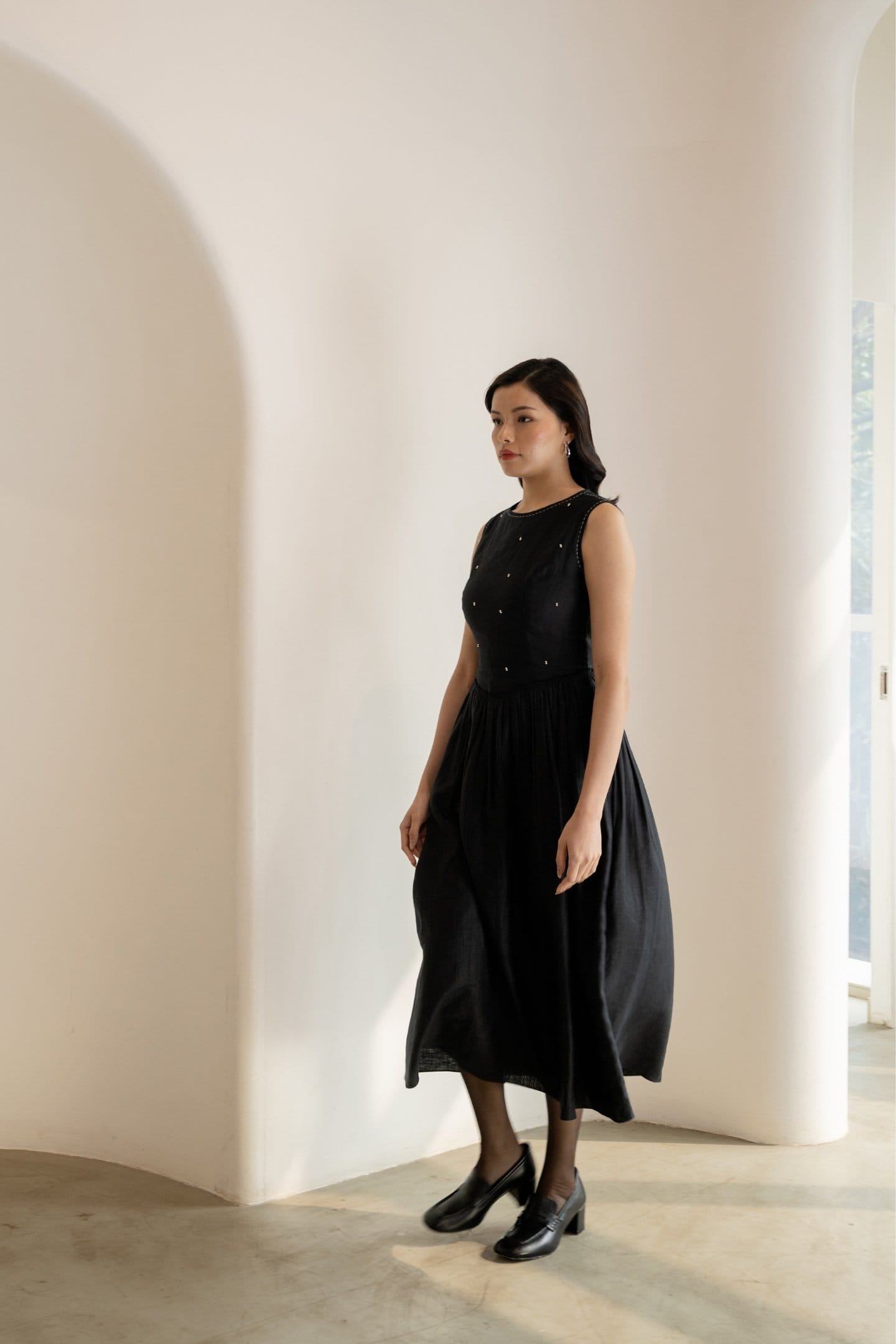 Ebony black sleeveless maxi dress by Alternative, flowing midi-length dress with a sleek, elegant silhouette.