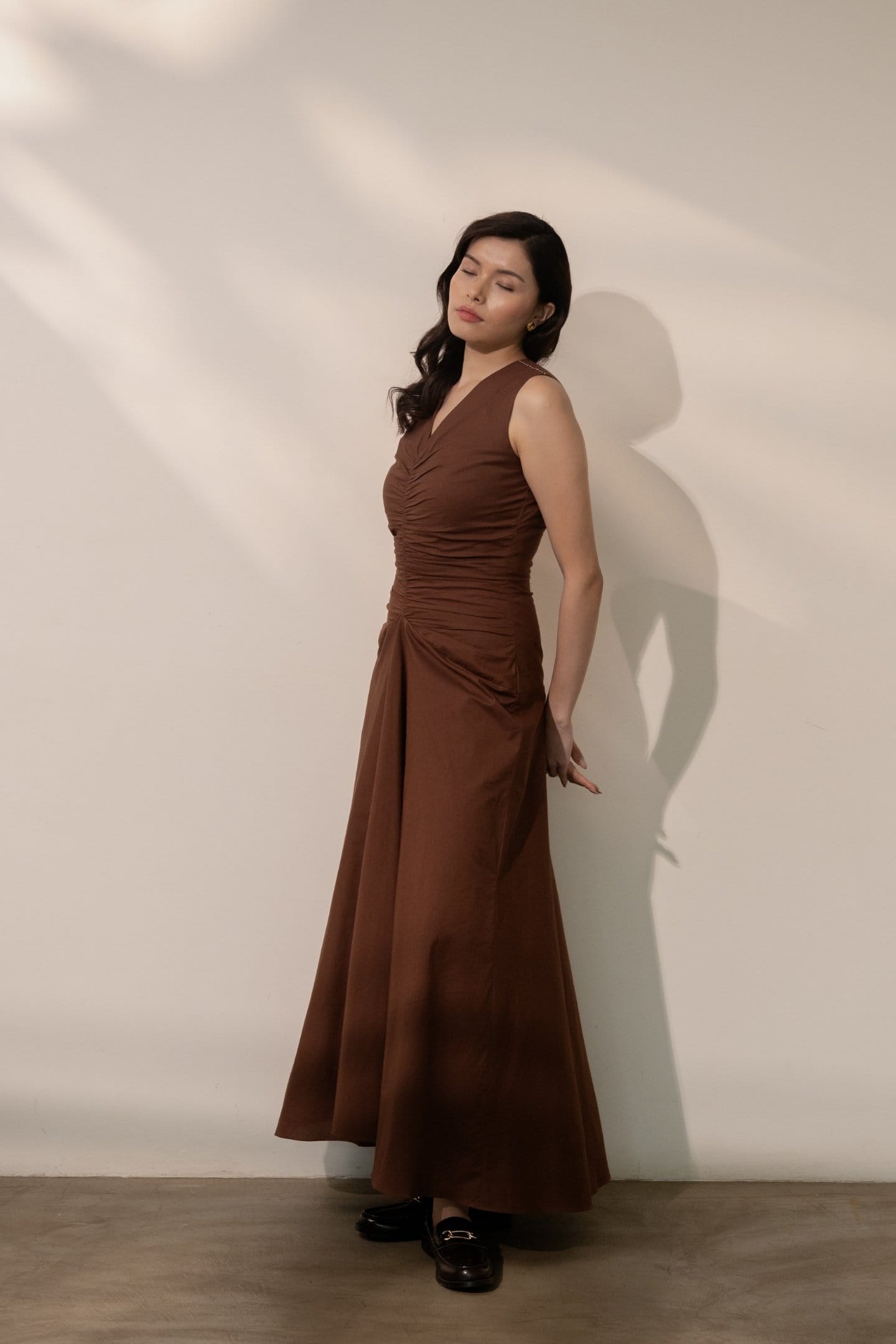 Alternative Ether brown maxi dress displayed on a hanger showing its flowy fabric and elegant design.