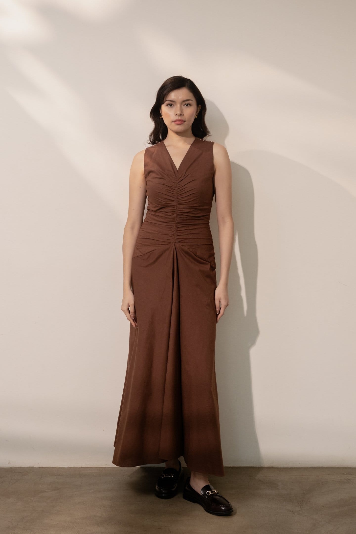 Alternative Ether brown maxi dress featuring a flowy silhouette and long sleeves, displayed hanging against a neutral background.