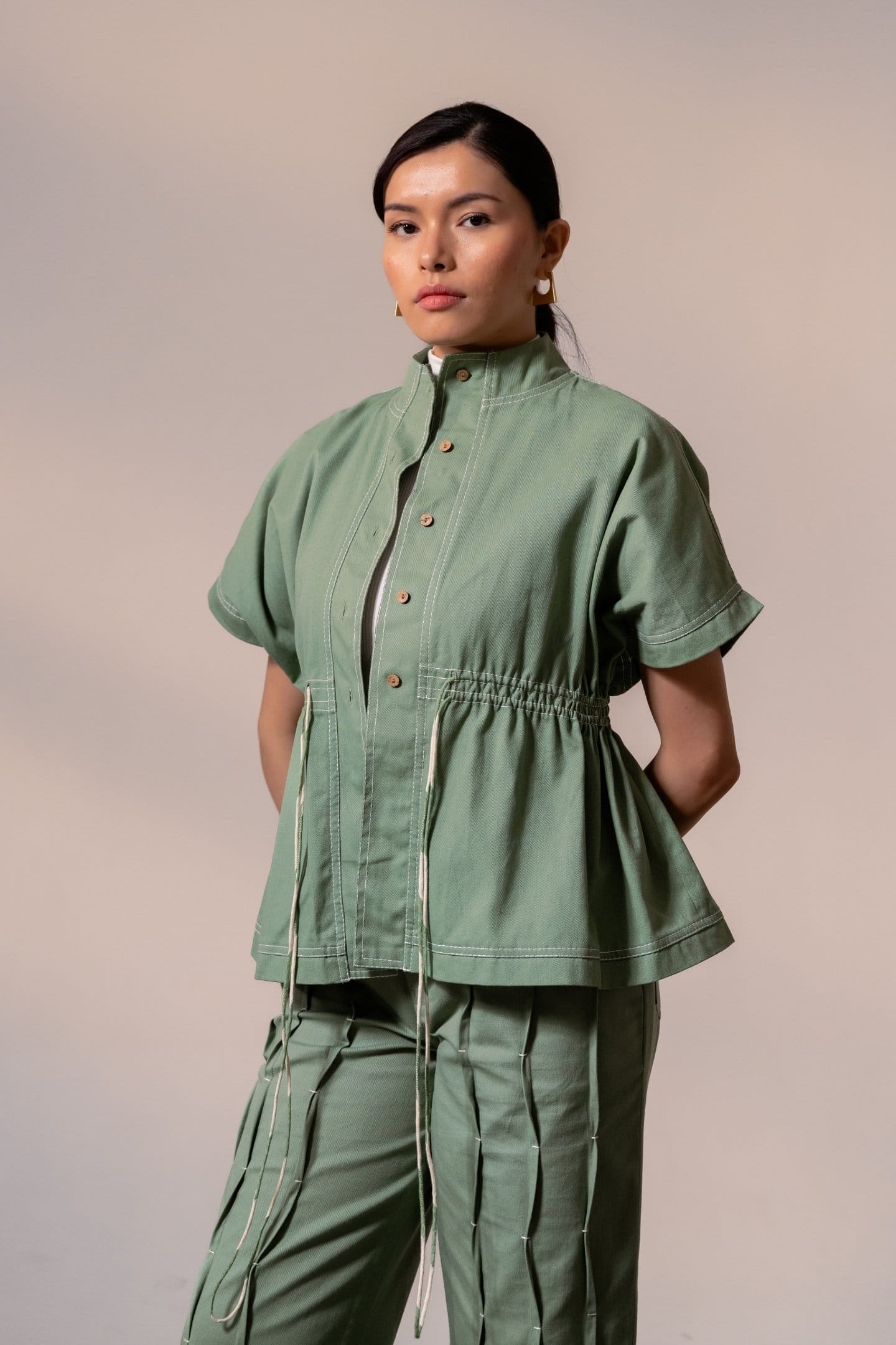 Fern green denim top from Alternative, casual sleeveless shirt with button details and relaxed fit, styled on a mannequin.