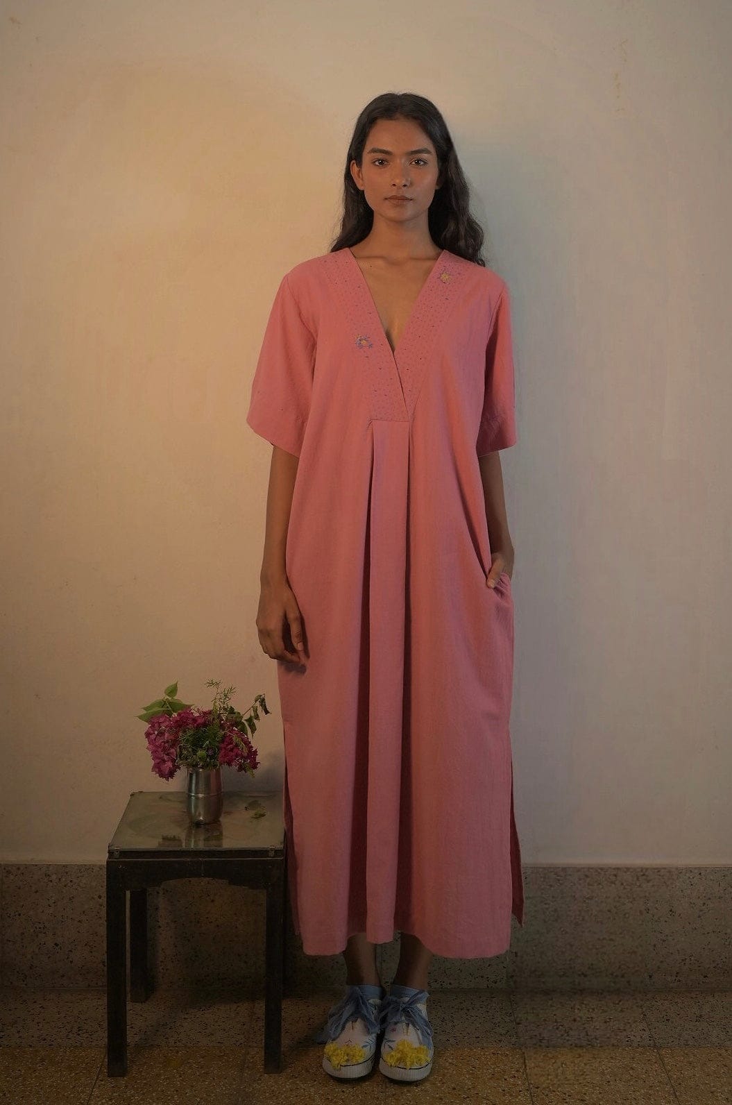 Deeta Rosa dress displayed on a hanger, showcasing its feminine design and soft pink fabric for stylish women's dresses