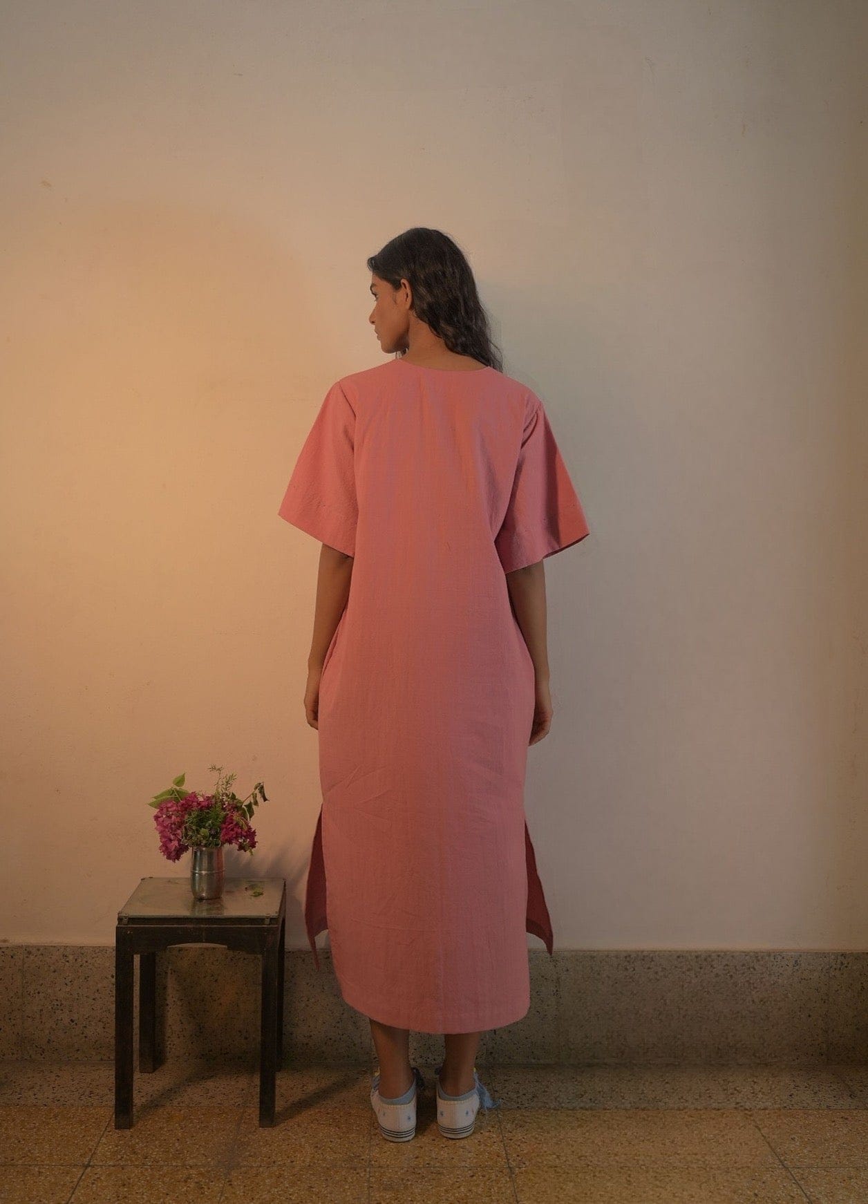 Deeta Rosa dress featuring a flowy, pastel-colored fabric with a fitted waist and elegant sleeve design.