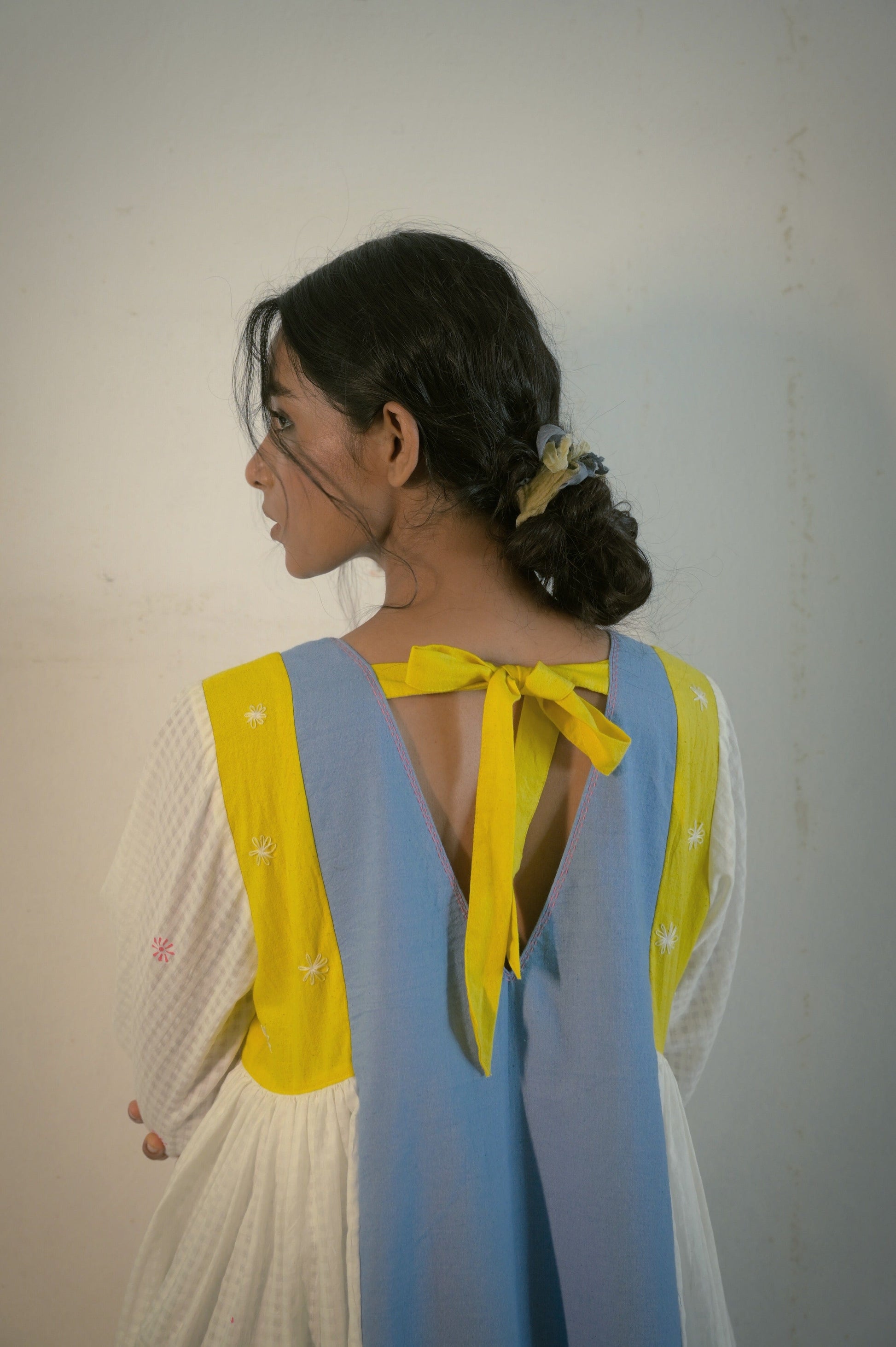 Deeta Kiku dress featuring a flowing design with floral patterns, worn by a model in a stylish outdoor setting.