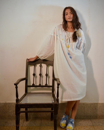 Deeta Flora oversized white dress displayed on a hanger, showcasing its flowing fabric and relaxed fit.