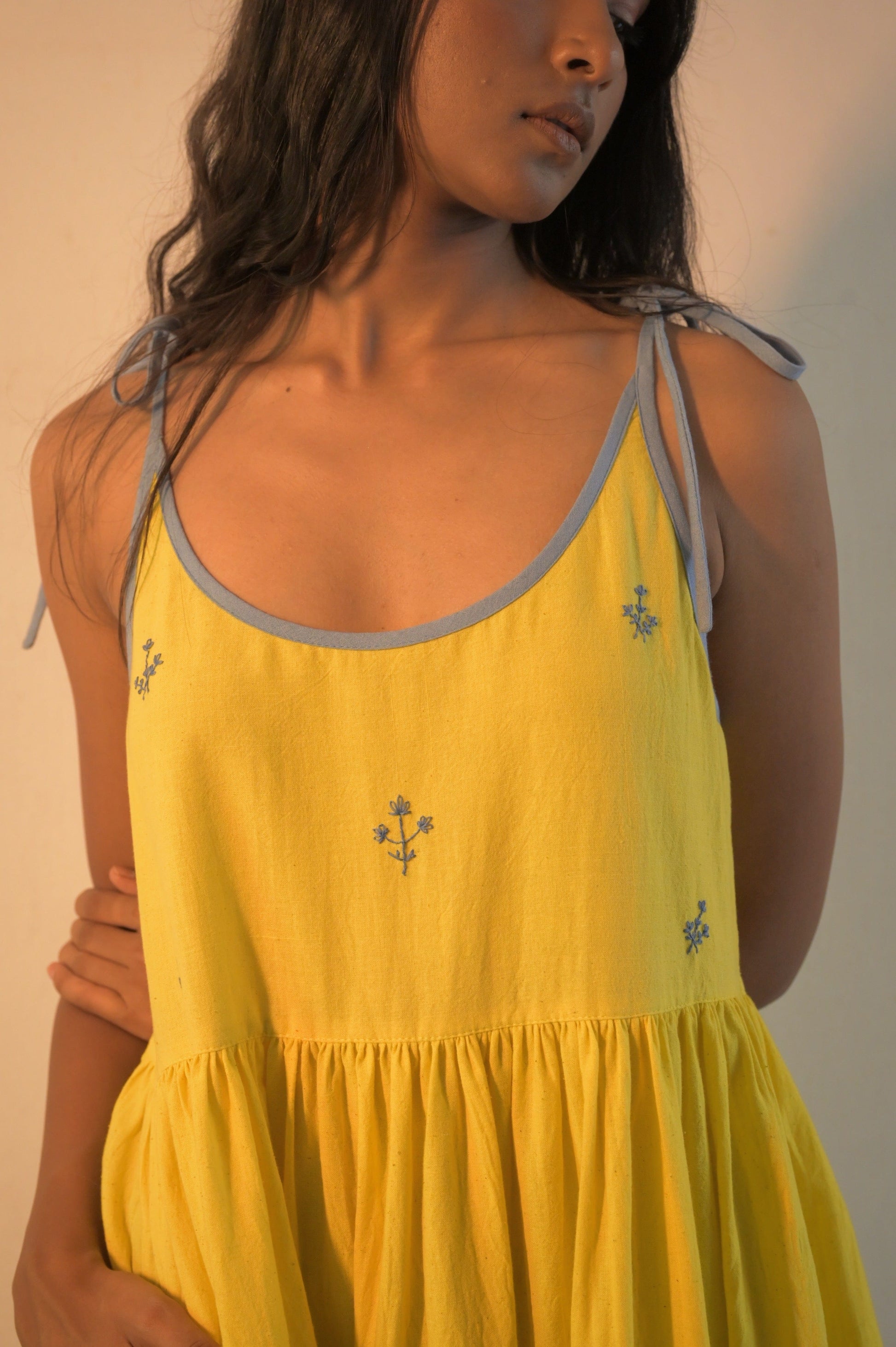 Deeta Kira slip dress featuring a sleek, fitted design with thin straps and a smooth fabric, ideal for elegant daytime wear.