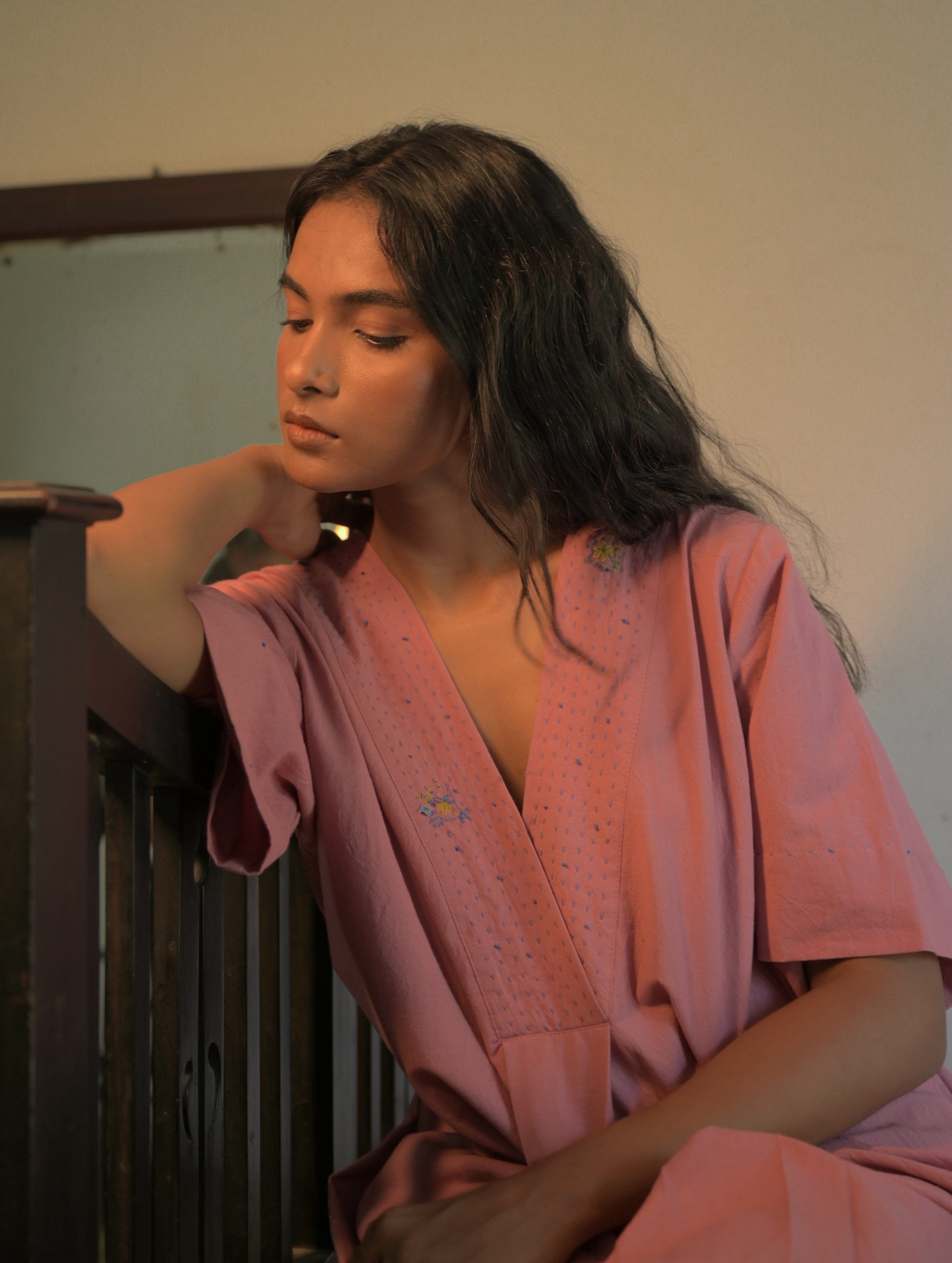 Deeta Rosa dress featuring a flowing pink fabric, sleeveless design, and elegant style perfect for special occasions.
