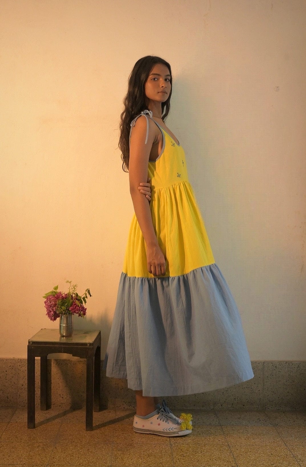 Deeta Kira slip dress in soft fabric with thin shoulder straps, lying flat to showcase its sleek, minimalist design.
