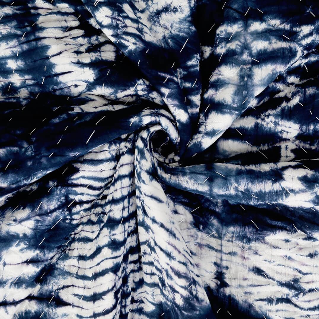 Close-up of Bombaybirds Indigo Shyburi Quilt made of soft cotton with textured indigo shibori pattern, perfect for living space decor.
