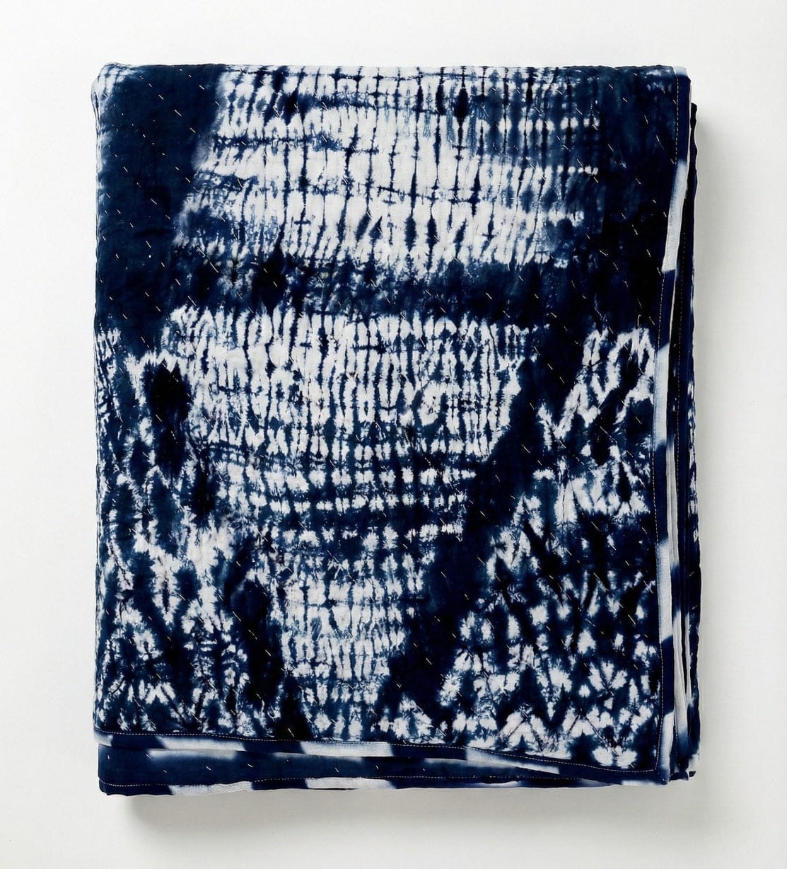 Handcrafted indigo shibori quilt by Bombaybirds, featuring traditional dyed cotton fabric with intricate deep blue patterns.