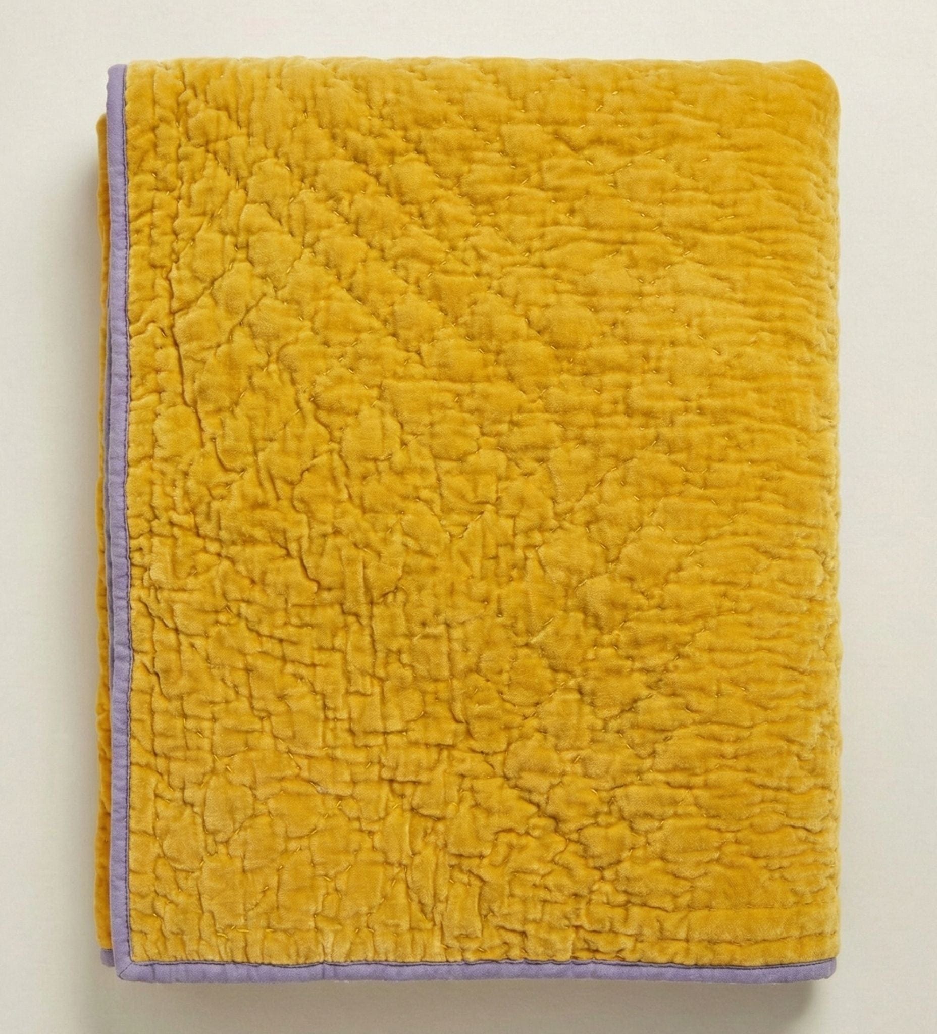 Kurkuma lilac velvet reversible quilt by Bombaybirds, showcasing plush velvet fabric in vibrant yellow and lilac tones.