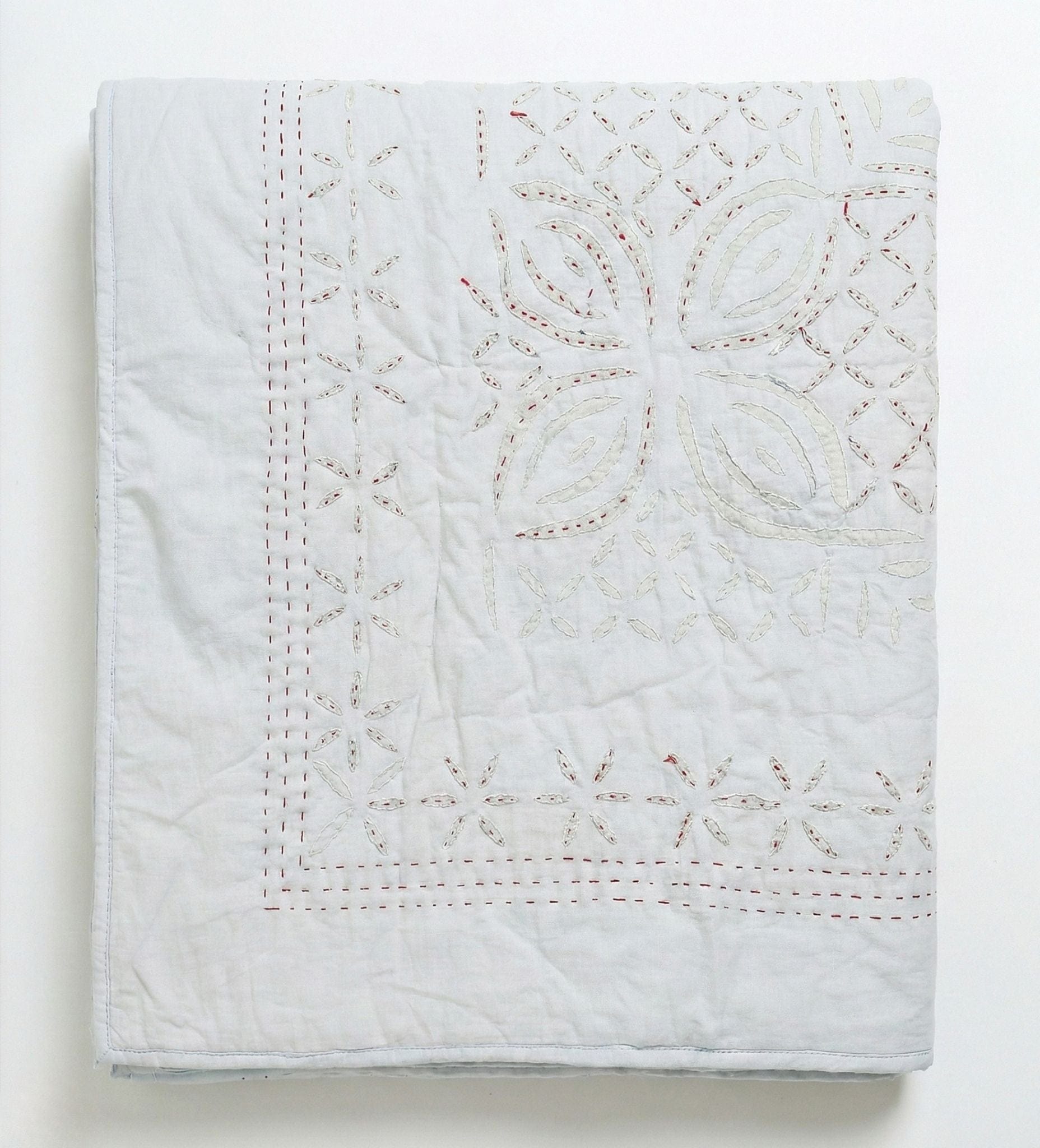 Bombaybirds sky quilt applique in grey-blue with textured fabric, ideal for living room decor and cozy ambiance.