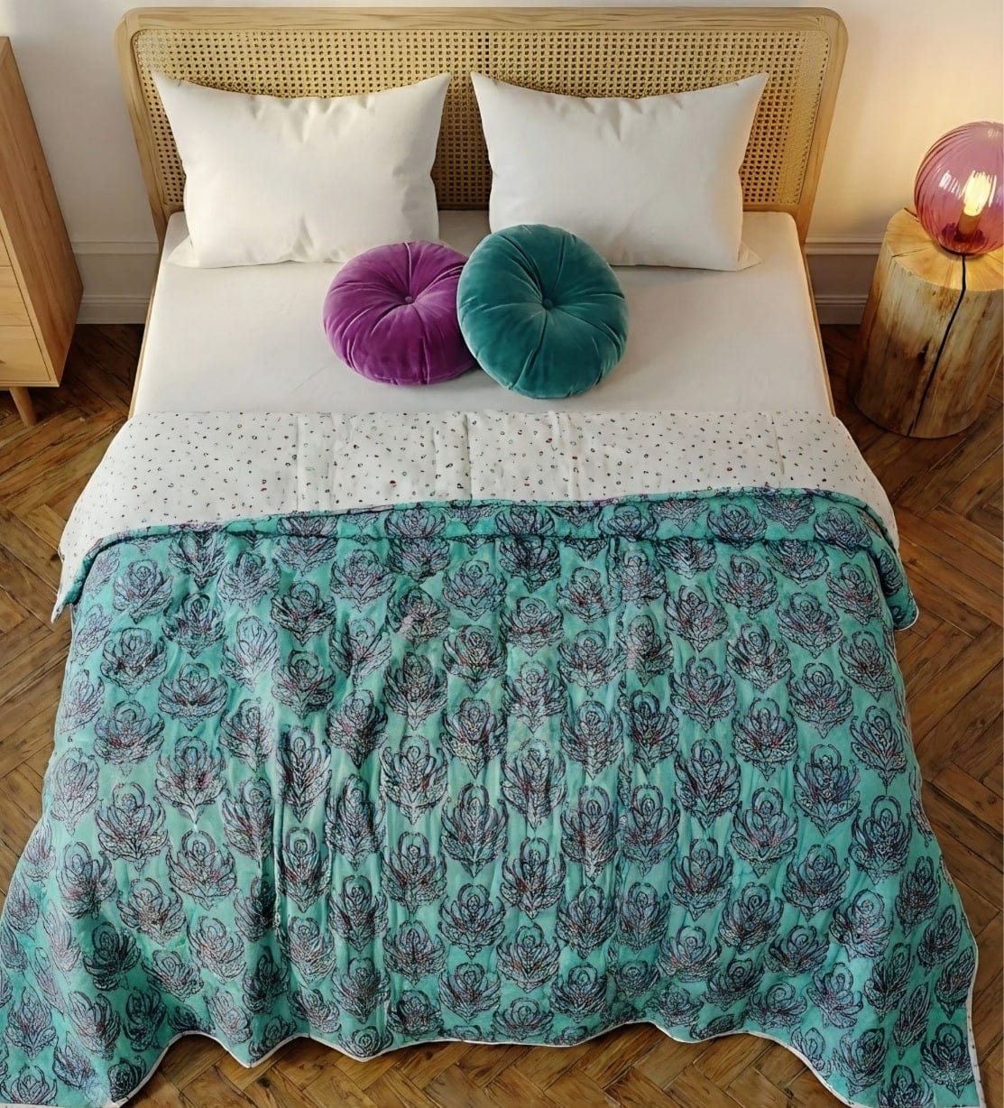 Reversible pink lotus quilt by Bombaybirds featuring soft cotton fabric with vibrant lotus designs on each side.