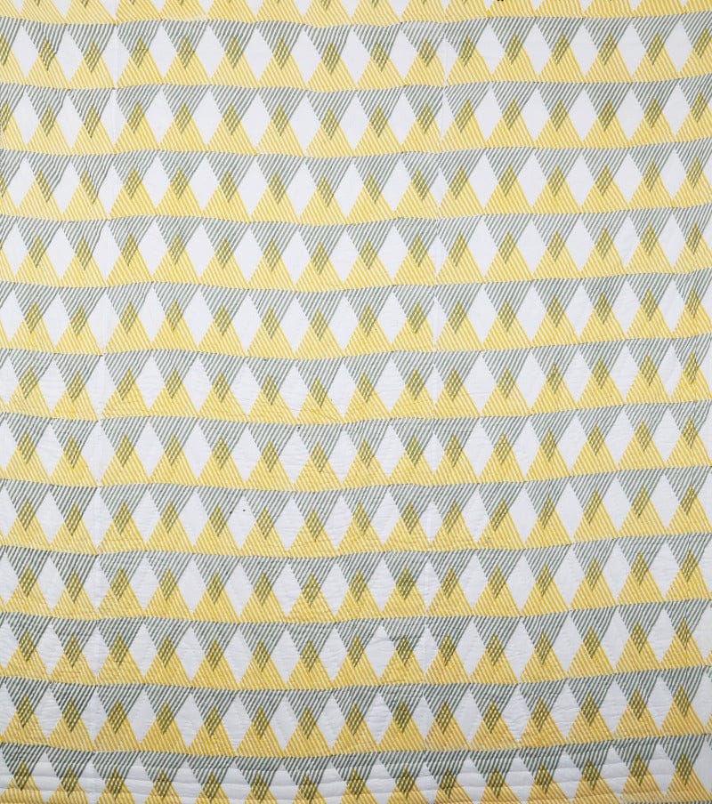 Reversible Sunnie chintz quilt by Bombaybirds featuring a yellow and gray floral pattern on living room bedding.