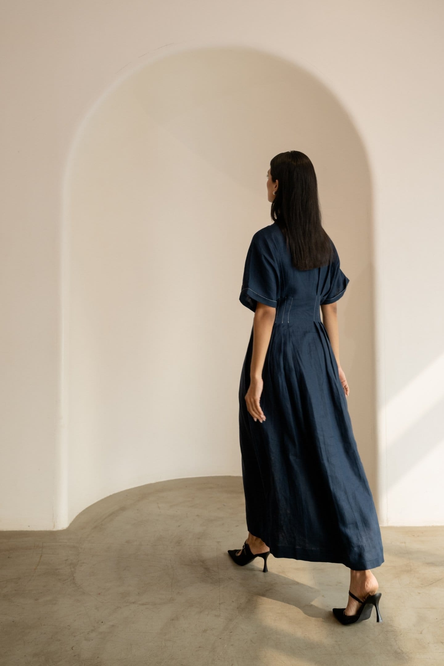 Navy blue Moraine maxi dress by Alternative, flowing fabric, sleeveless design, and elegant silhouette displayed on a mannequin.