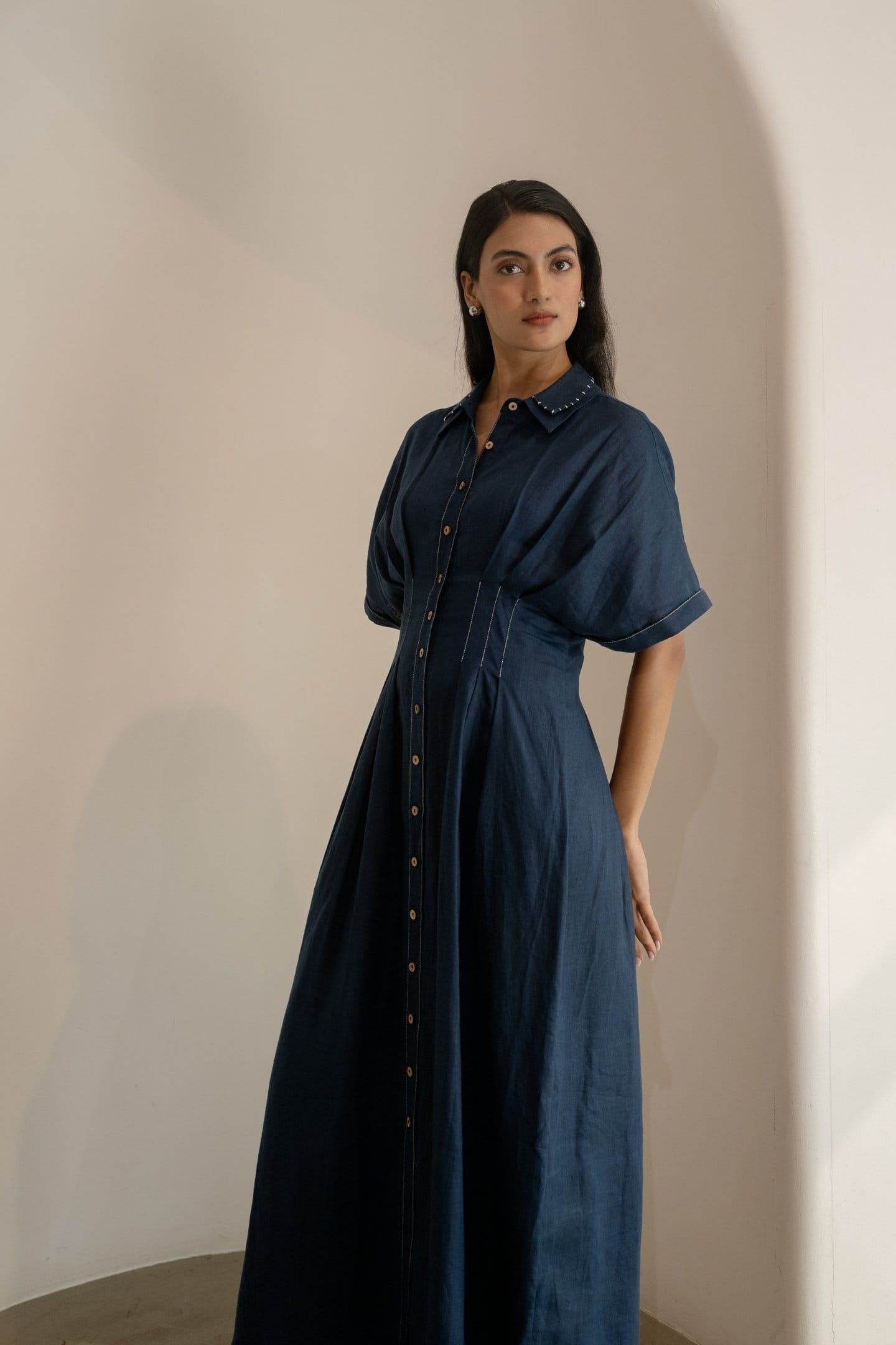 Navy blue Alternative Moraine maxi dress with flowing fabric and elegant design, displayed on a hanger.