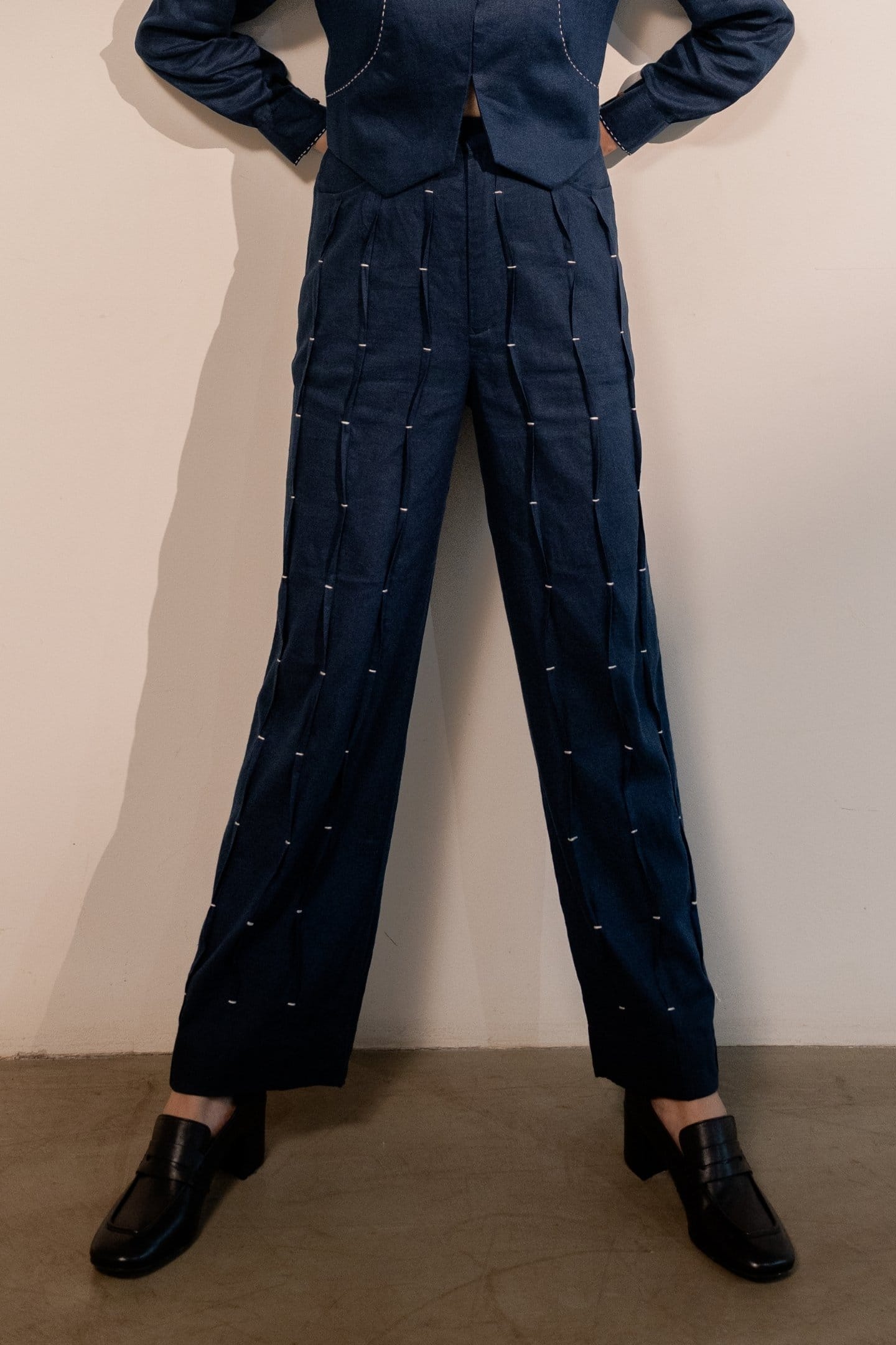 Navy blue Moraine pleated trousers by Alternative, showcasing the tailored waistband, pleats, and relaxed fit.