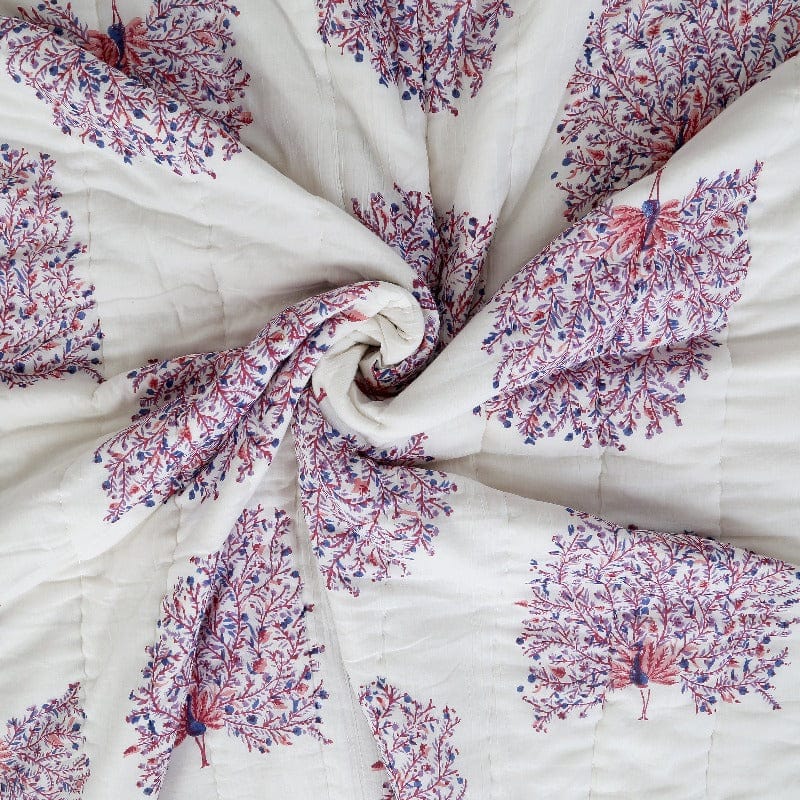 Reversible quilt with peacock feather pattern by Bombaybirds, featuring soft cotton texture and vibrant peacock feather designs.