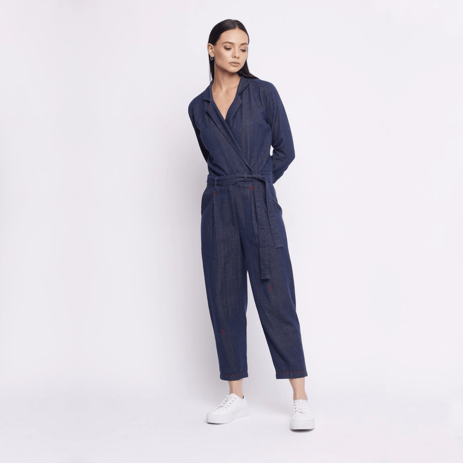 Doodlage upcycled denim jumpsuit featuring a relaxed fit, button front, and adjustable straps, displayed on a hanger.