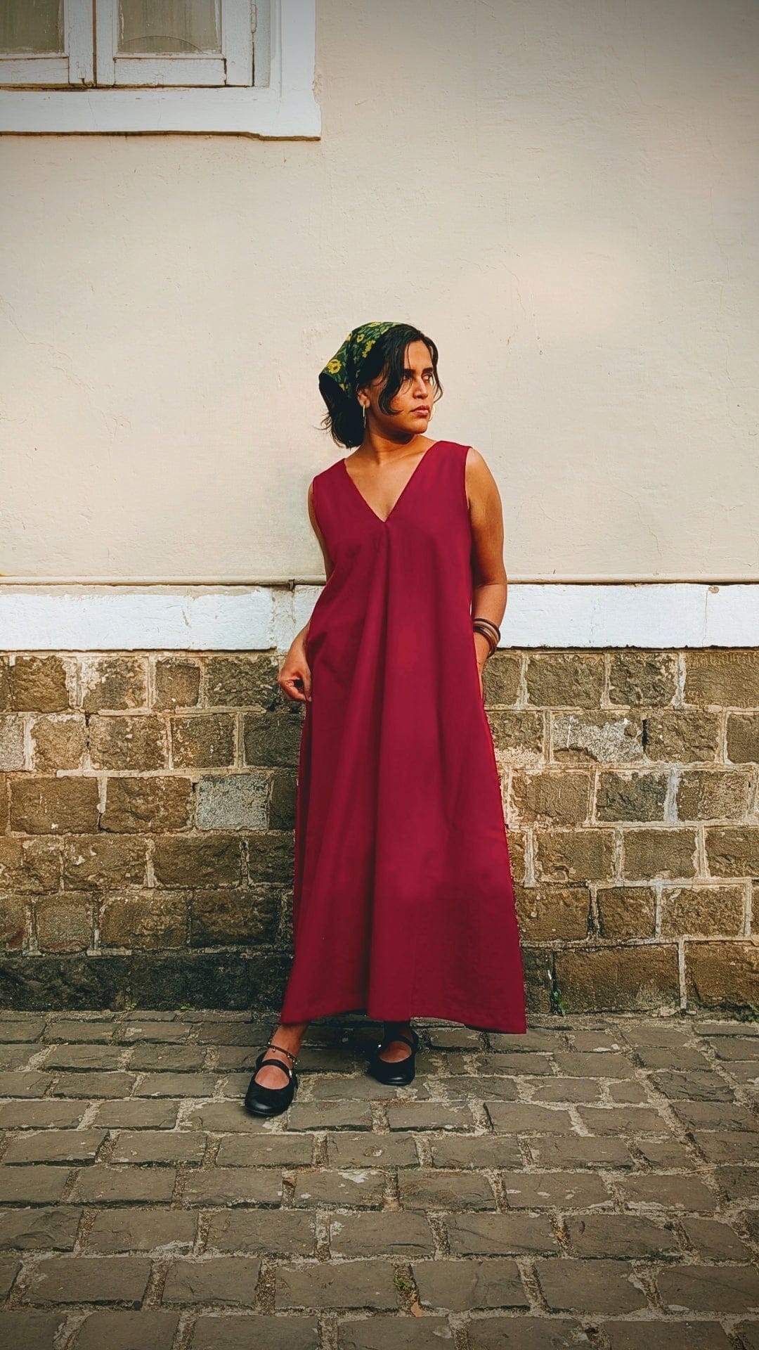 Deeta Ruby dress displayed on a mannequin, featuring a vibrant red fabric with a fitted bodice and flowing skirt.