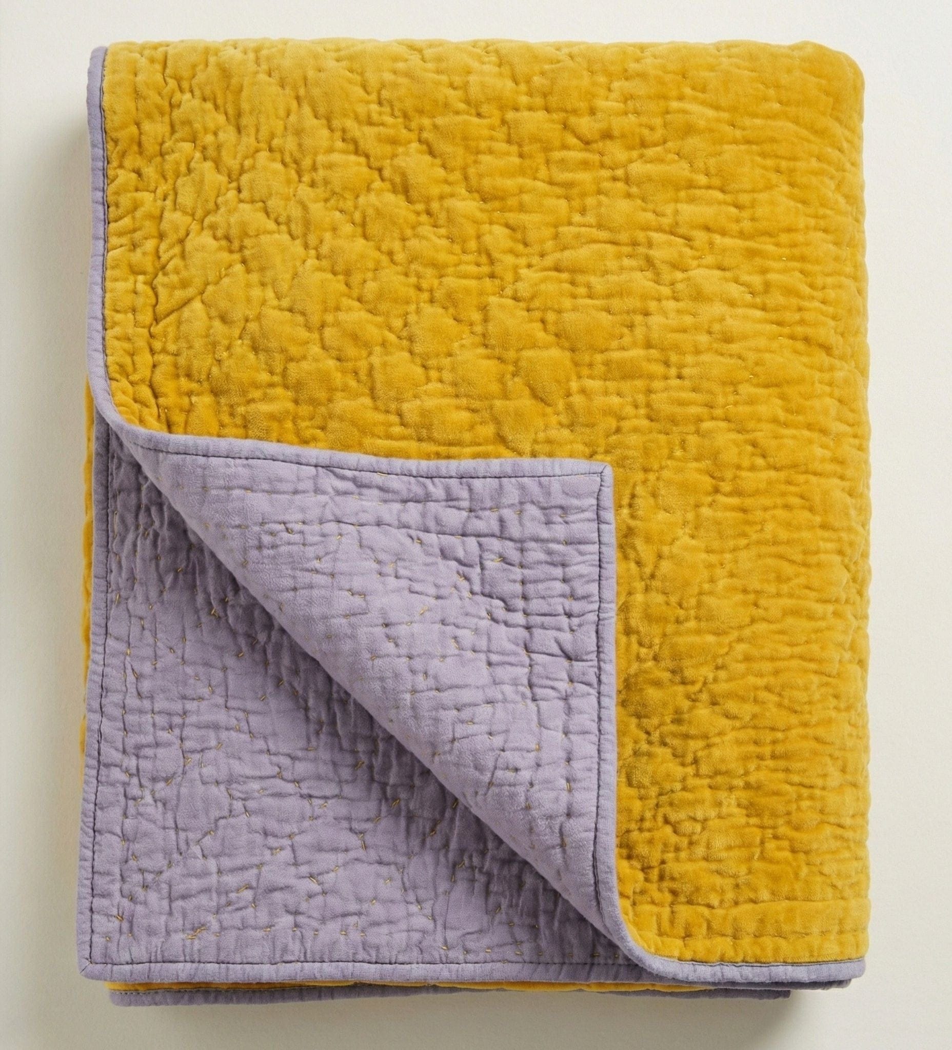 Reversible Kurkuma Lilac velvet quilt from Bombaybirds, living room decor with soft, plush fabric and vibrant color contrast.
