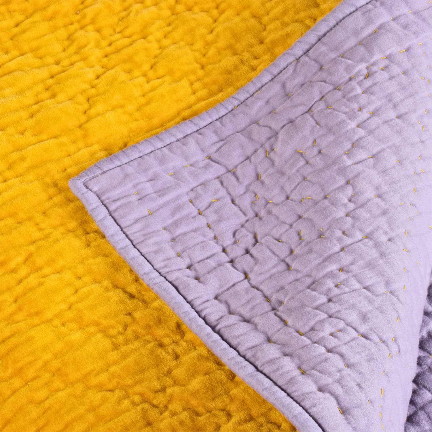 Close-up of Bombaybirds Kurkuma lilac velvet reversible quilt with detailed quilting and plush texture.