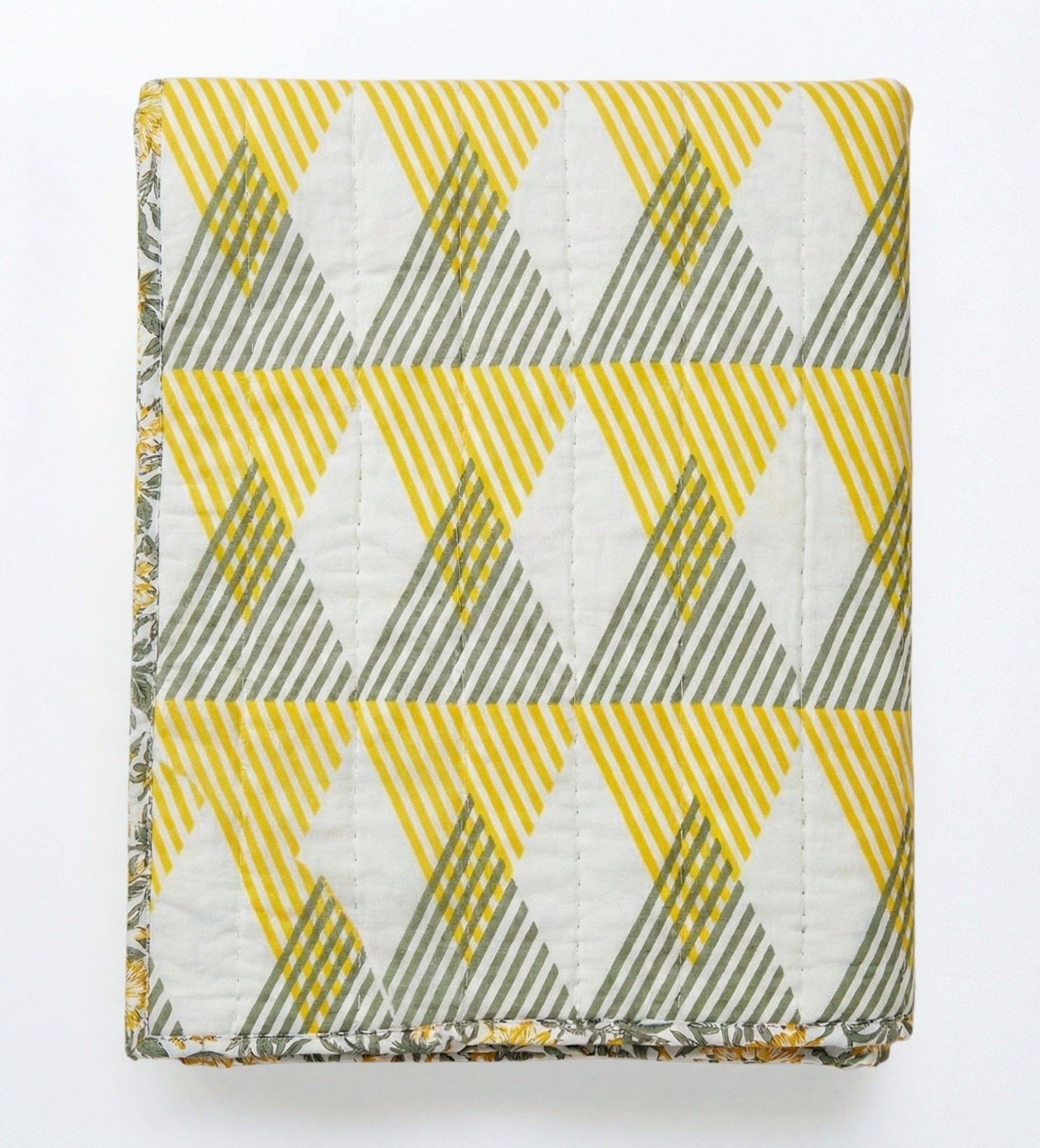 Reversible Sunnie Chintz quilt in yellow and gray with geometric pattern, made of cotton, by Bombaybirds for living room decor.