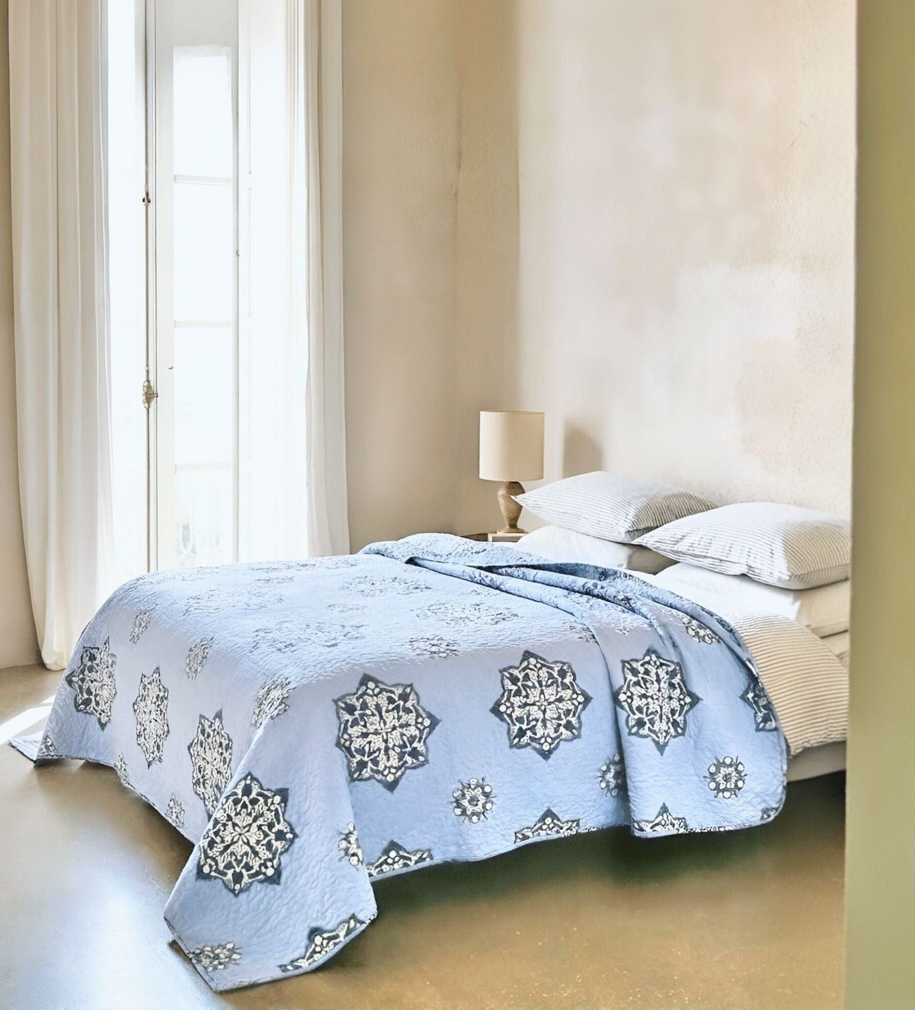 Lilac Suzani quilt in blue with intricate floral patterns, perfect for living room or bedroom decor by Bombaybirds.