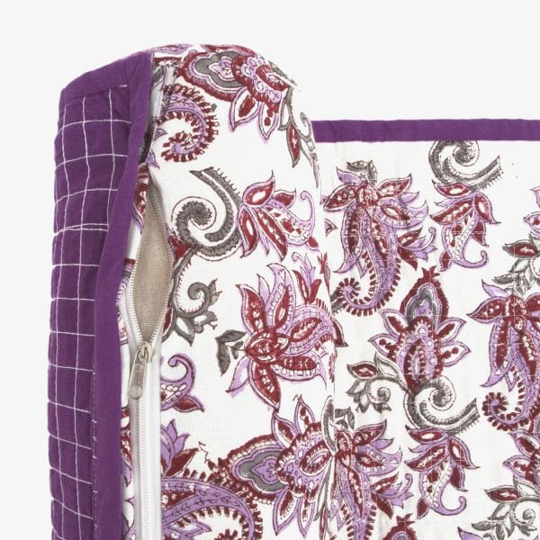 Violet chintz beach mat by Bombaybirds, featuring floral pattern and lightweight fabric, laid out on sandy beach surface.