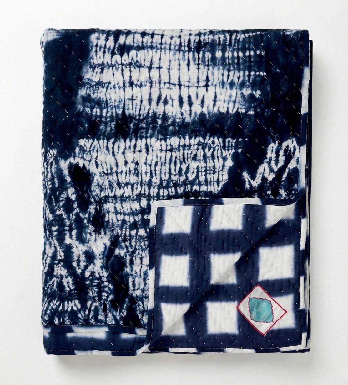 Indigo Shyburi quilt by Bombaybirds, organic living decor with vibrant shibori patterns on soft fabric.