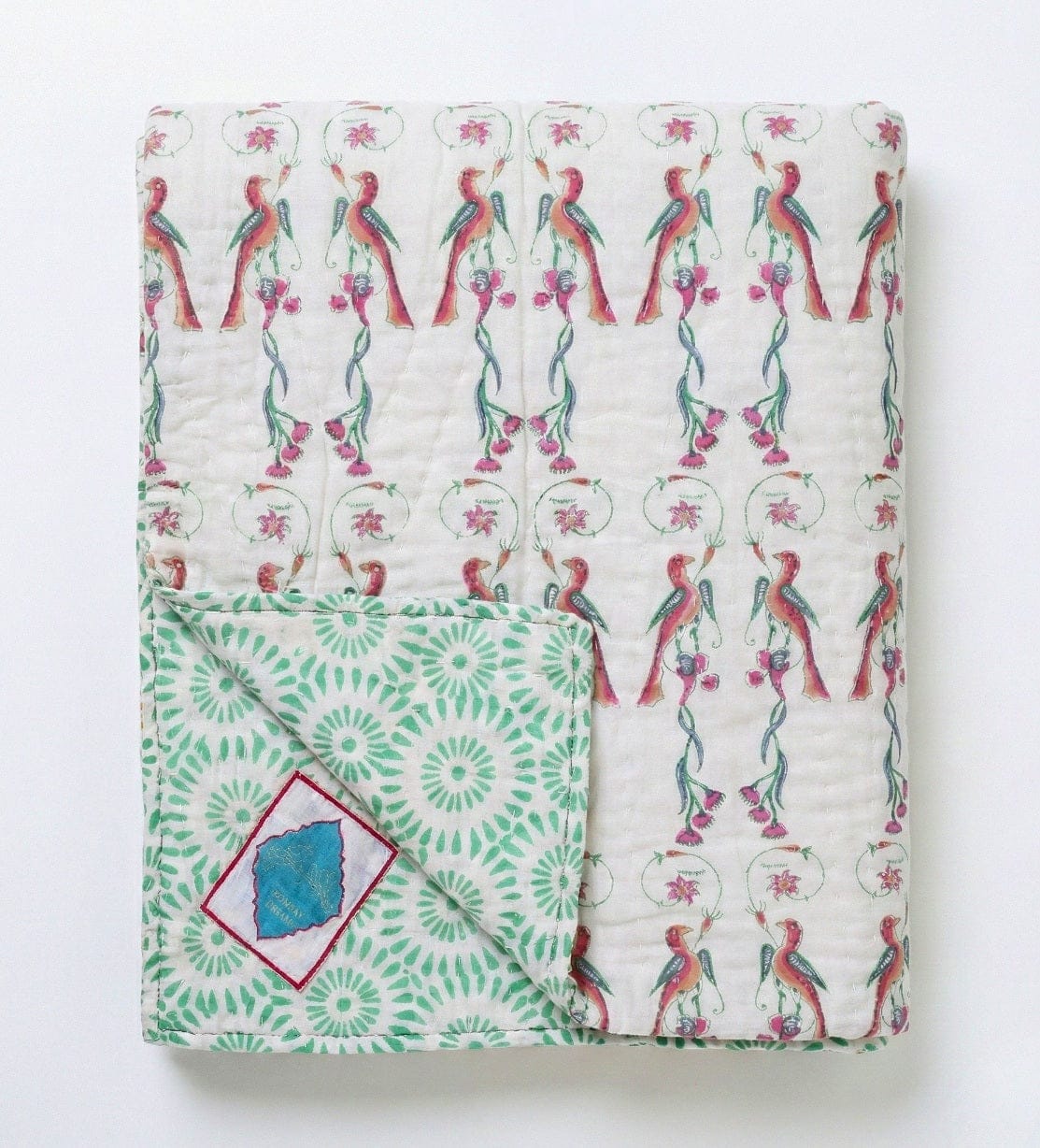Reversible Ornitho blanket by Bombaybirds featuring green and white geometric patterns for living room decor.