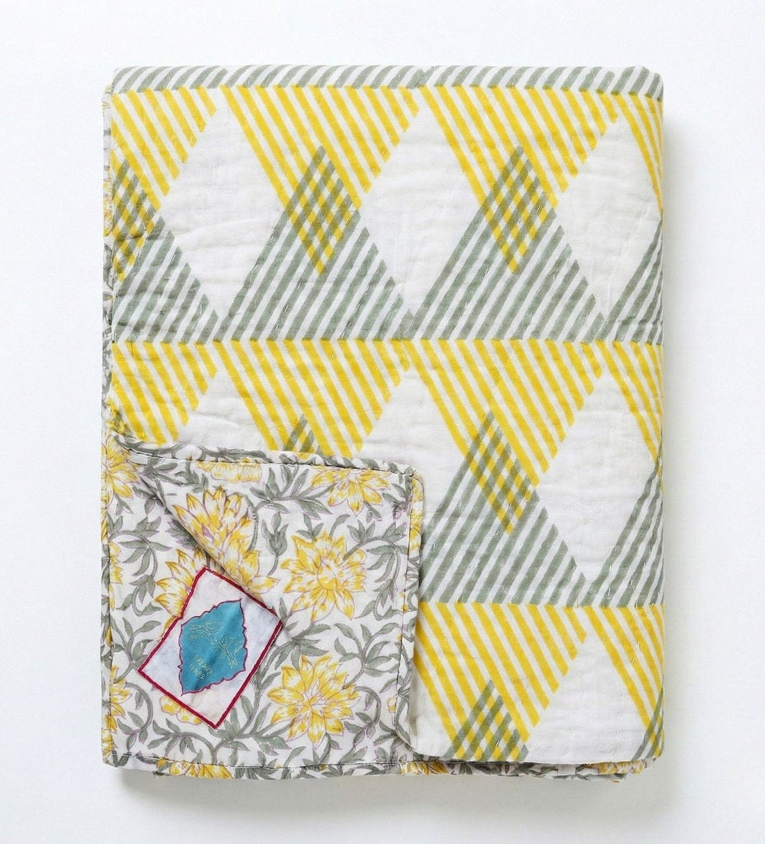 Reversible Sunnie Chintz quilt in yellow and gray with geometric pattern, made of cotton, by Bombaybirds for living room decor.